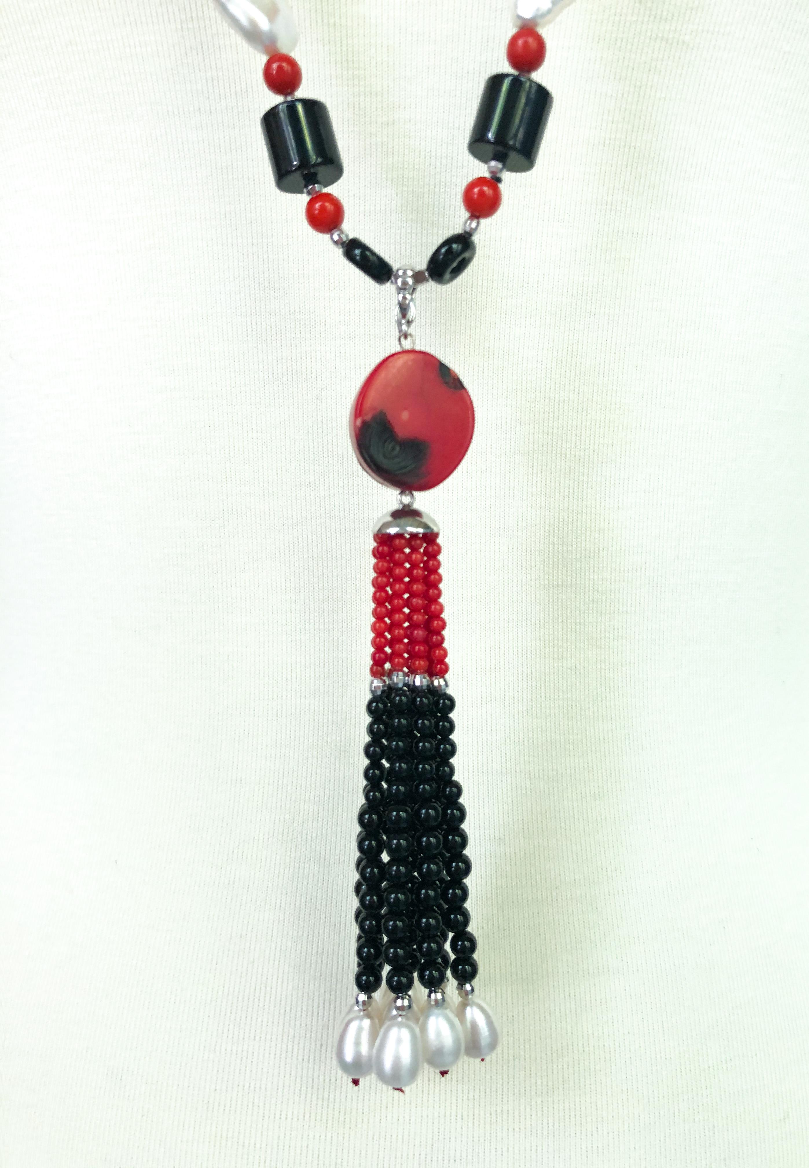 Marina J.'s unique art deco style necklace features a variety of shapes: sphere pearls, cylindrical onyx beads, coral teardrop beads, and more. This striking piece mimics jewelry from the roaring '20s with its symmetrical design and various