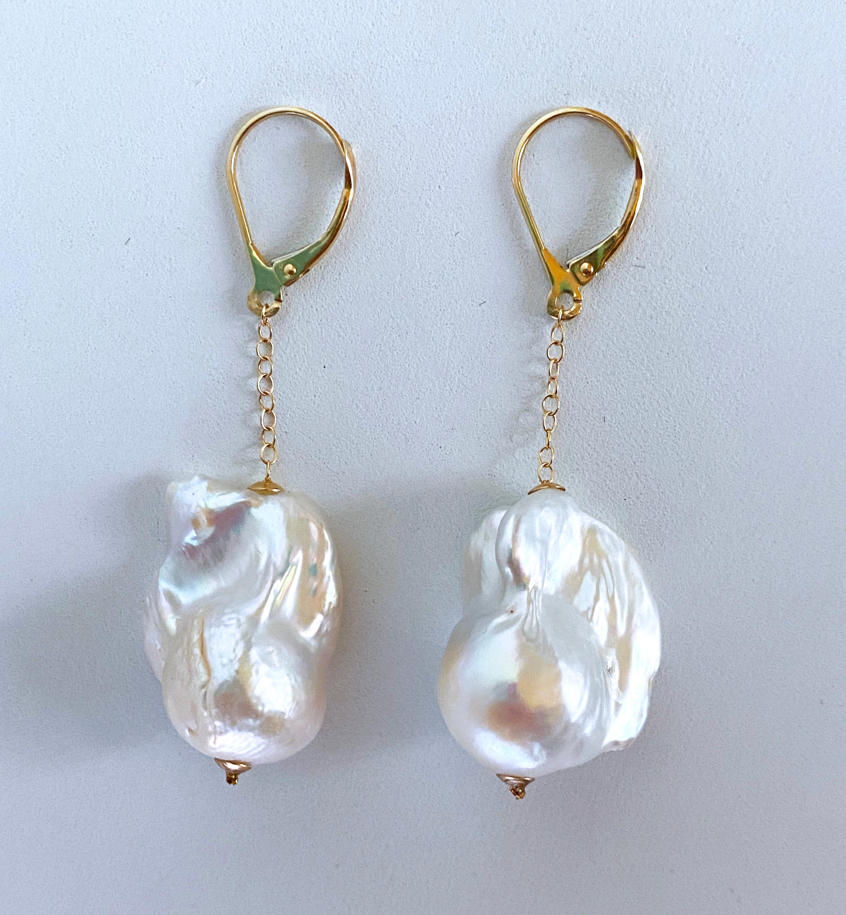 Beautiful pair of Earrings by Marina J. This pair is made of two cultured Baroque Pearls displaying a fine iridescent luster which flash soft hues of pinks, blues, greens and purples. The Baroque Pearls sit within two small solid 14k Yellow Gold