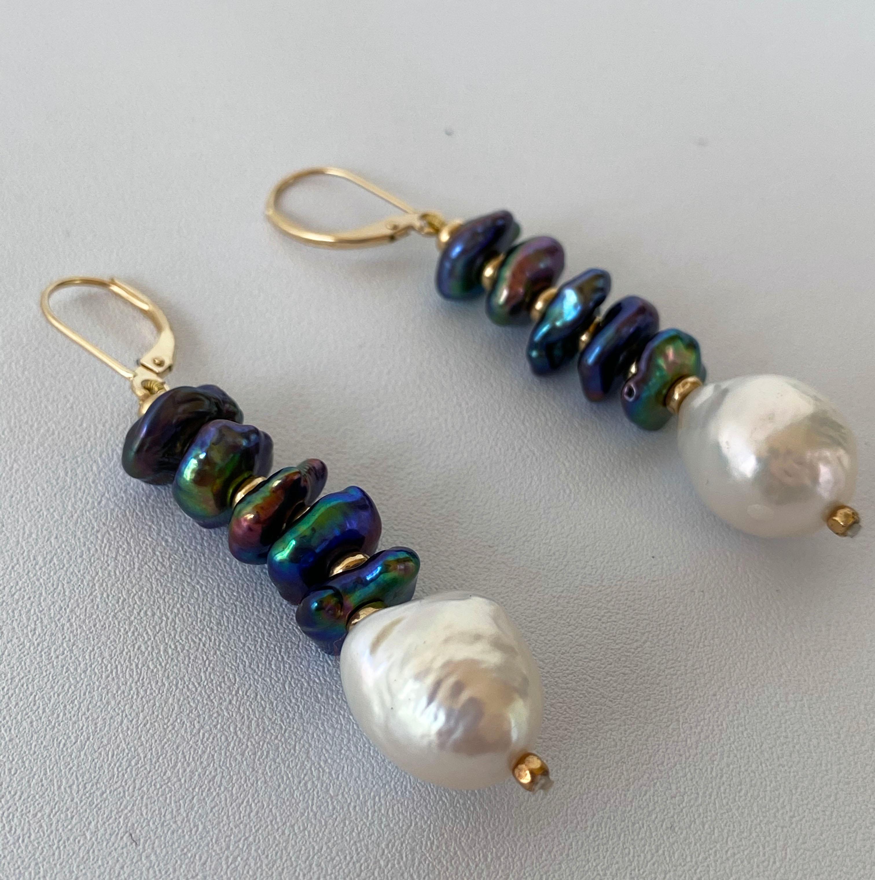 These stunning earrings feature bright iridescent Black oil spill / peacock Pearls separated by contrasting Gold plated Roundales. The bright contrast between the textured Black Pearls and Gold is perfectly balanced with a large smooth Baroque White