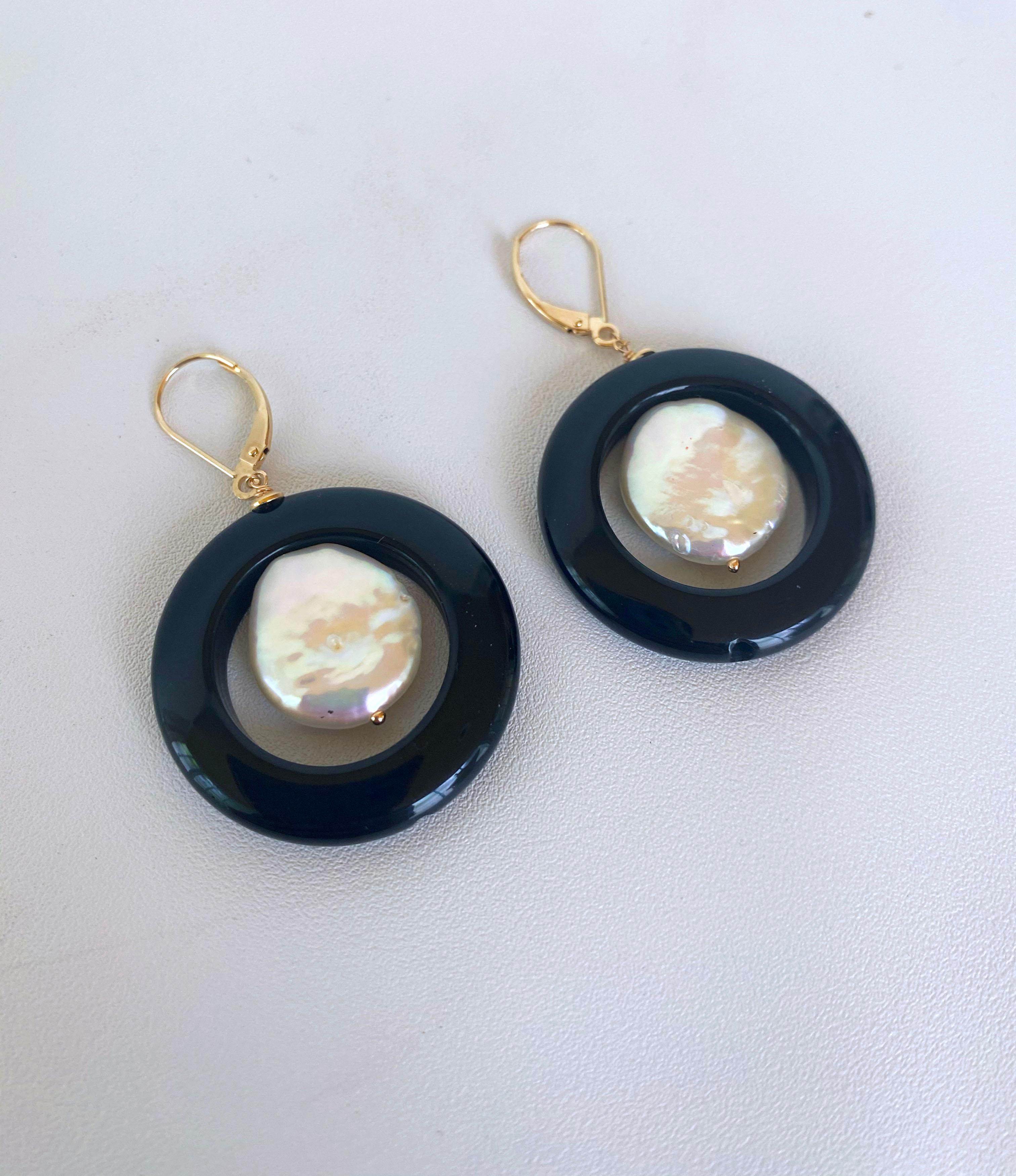 Bold and simple Black Onyx earrings with a high luster gorgeous coin Pearl dangling within. These earrings have a very simple yet powerful way of elevating any outfit and are a perfect addition to any formal evening wear. These earrings measure to 2