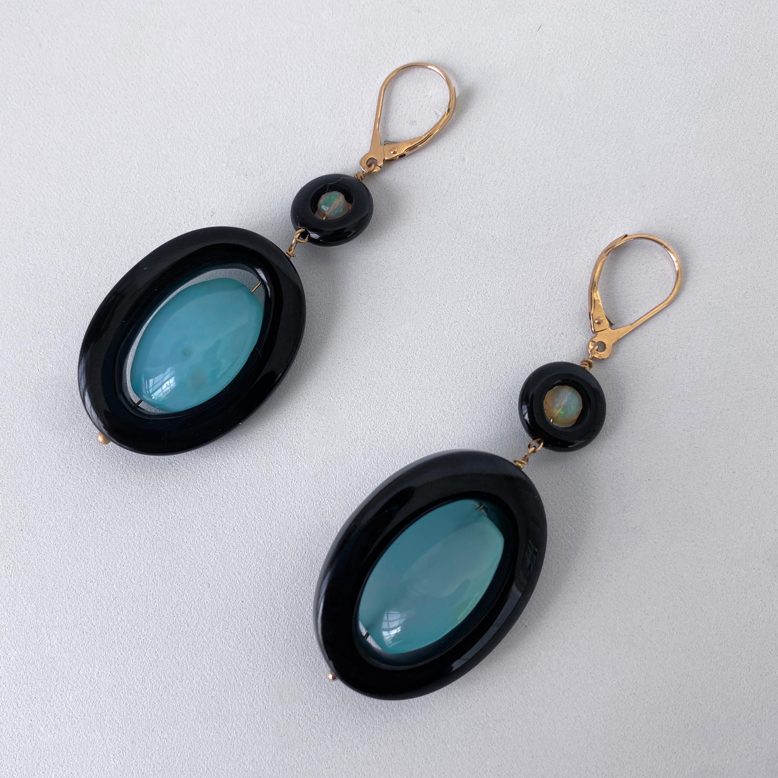 Beautiful pair of Earrings by Marina J.
Measuring 2.5 inches long, this pair is made with all solid 14k Yellow Gold wiring and Lever Back Hooks. Faceted Fire Opal and Faceted Chalcedony sit within high gloss Black Onyx Donut beads. Due to their semi