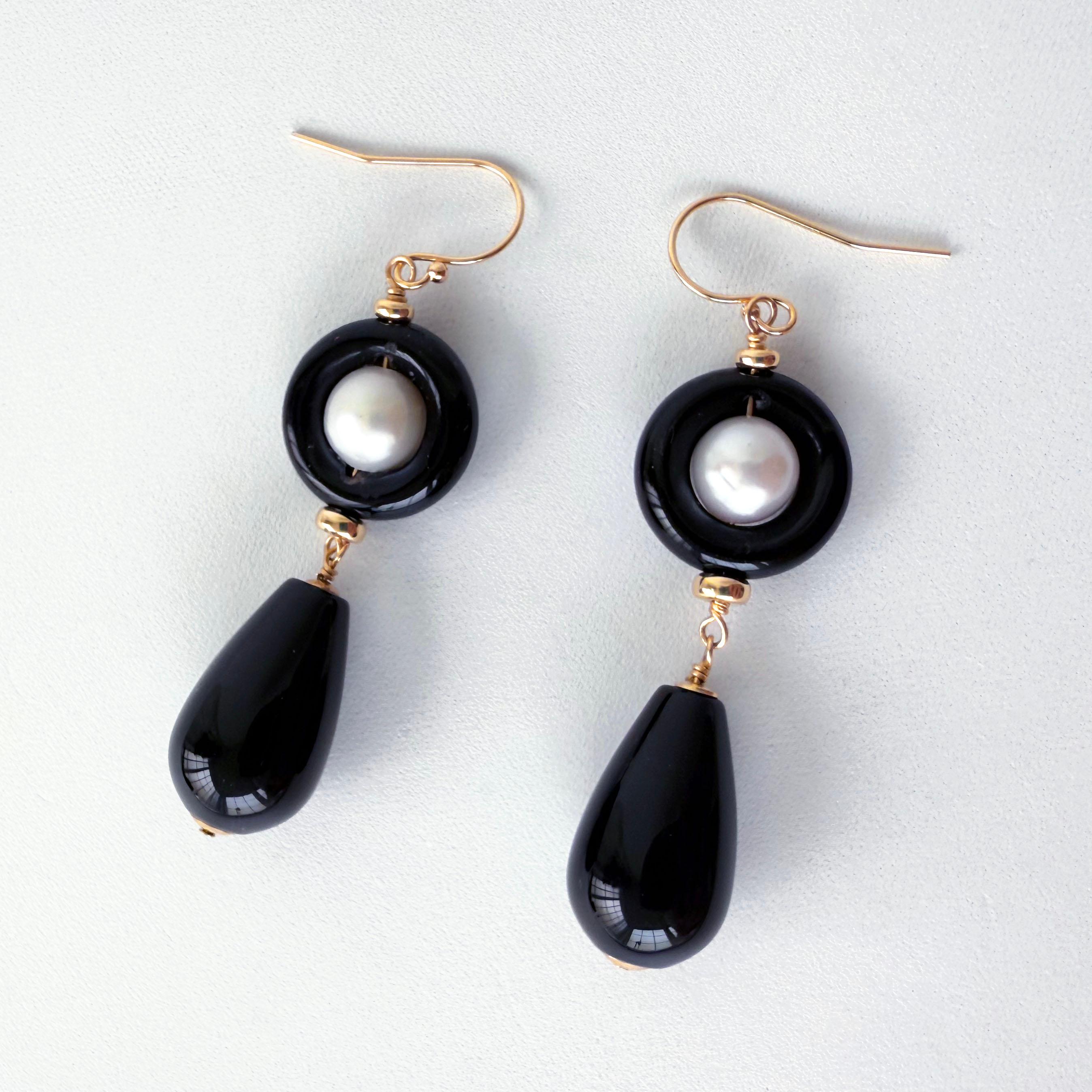 Gorgeous pair of Earrings by Marina J.
This pair features a round Pearl sitting within a smooth Black Onyx Donut, from which a large Black Onyx teardrop bead hangs. Made entirely with Solid 14k Yellow Gold wiring and Findings, each piece in this