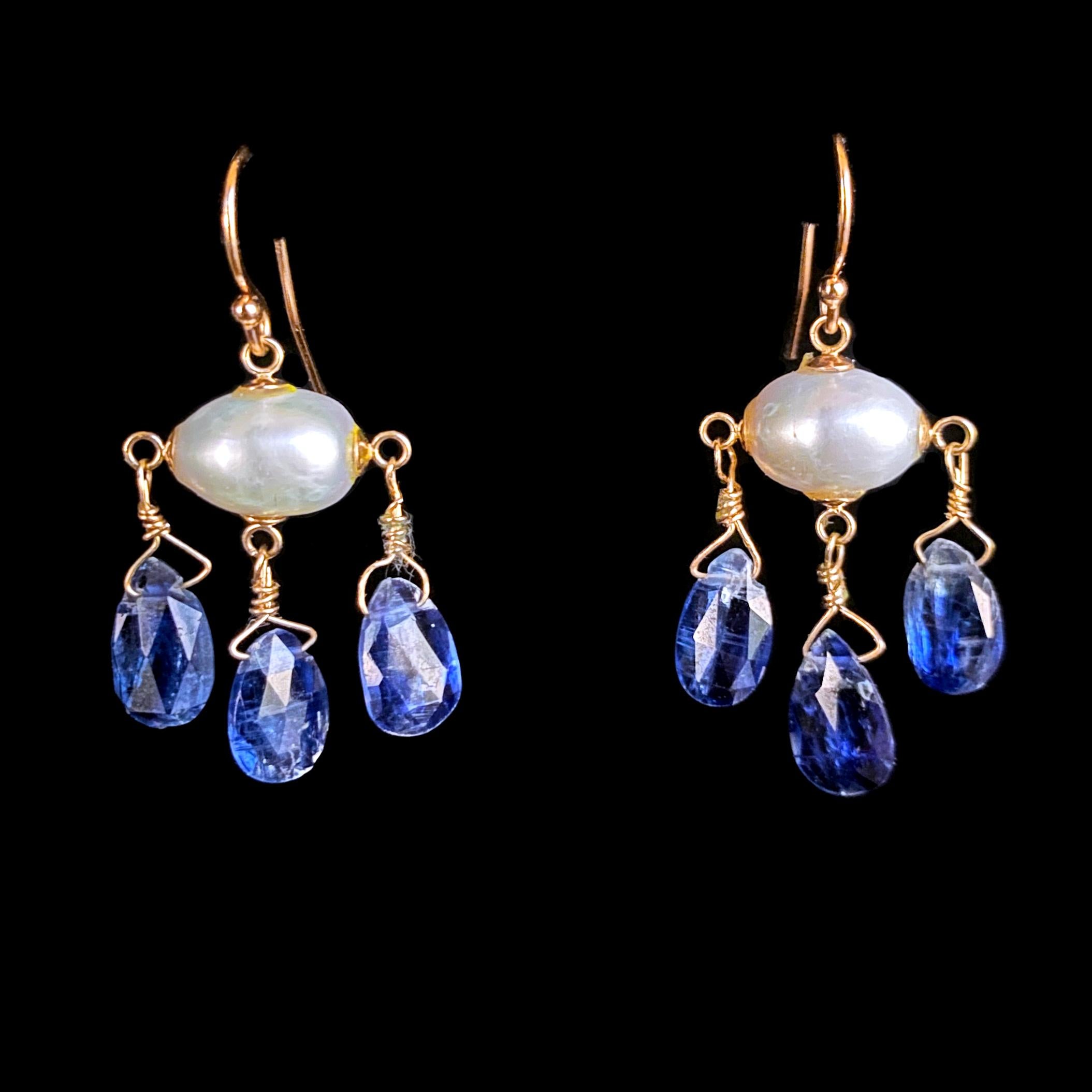 Stunning pair of Earrings by Marina J. This pair is made with all solid 14k Yellow Gold wiring and hooks. A Baroque Pearl with a beautiful iridescent luster sits as three vivid Blue Kyanite teardrop Briolettes hang from it. The Blue Kyanite display