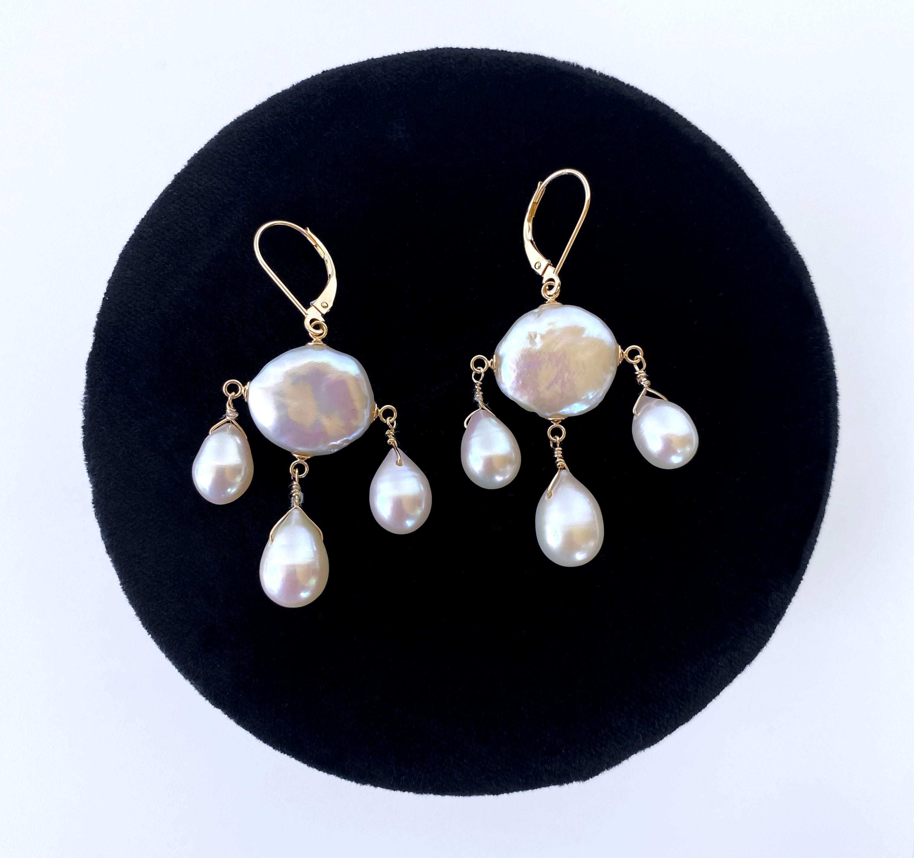 Gorgeous pair of chandelier handmade earrings by Marina J. This lovely pair feature high luster white Pearls that display beautiful hues of pinks and blues when hit with light. A large Baroque Coin Pearl hangs in the middle, from which three