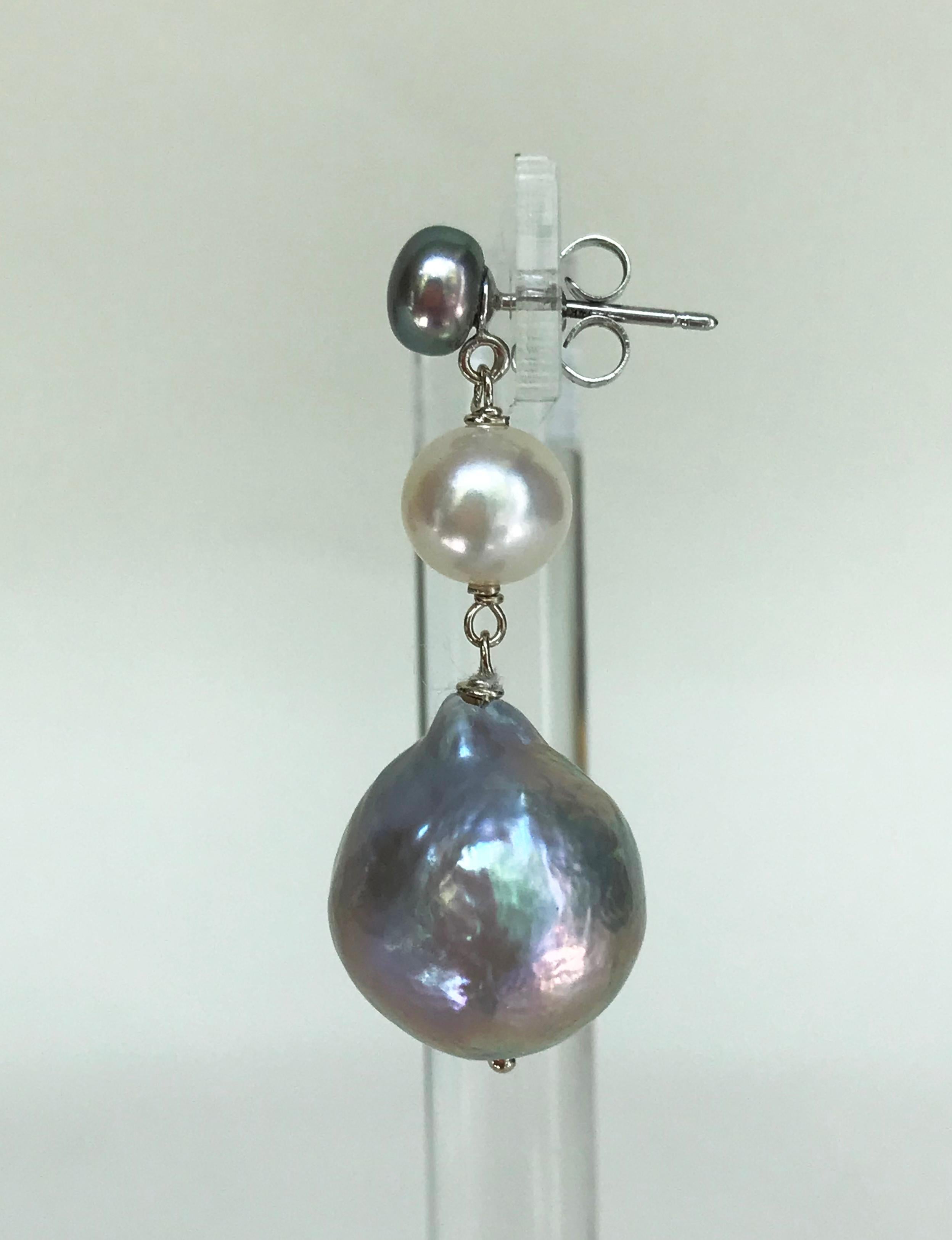 These beautiful and elegant earrings are handmade with a fine 4mm dark grey pearl, a 6mm white pearl, and a 15mm light grey pearl with 14K white gold for the wiring and stud. They are 1.25 inches in length. Perfect for every occasion, highlighting