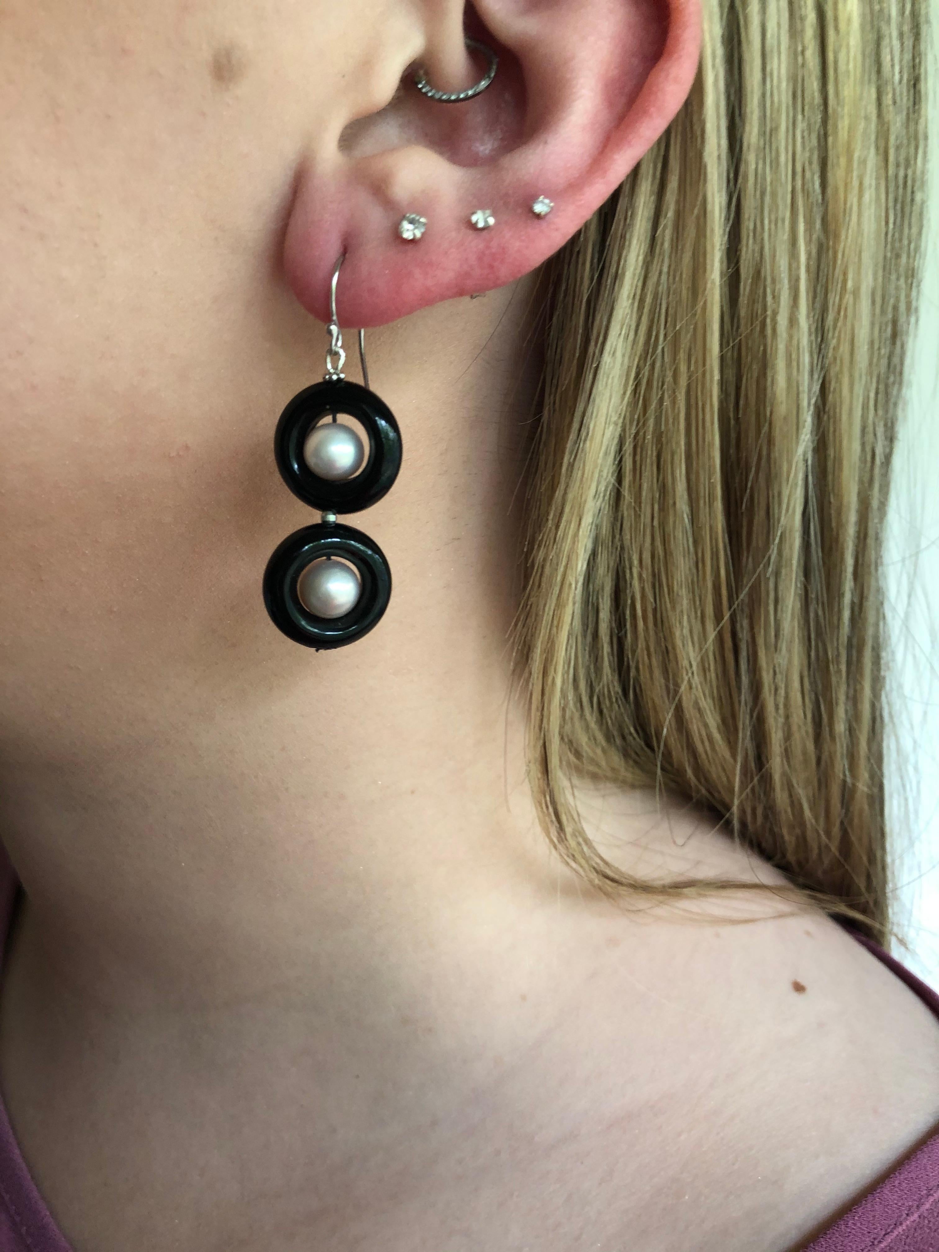 These classic double black onyx and pearl earrings with 14 k yellow gold lever-back and wiring are elegant and bold. The onyx rings contrast with the glowing white pearls beautifully making, what could have been simple earrings dramatic and