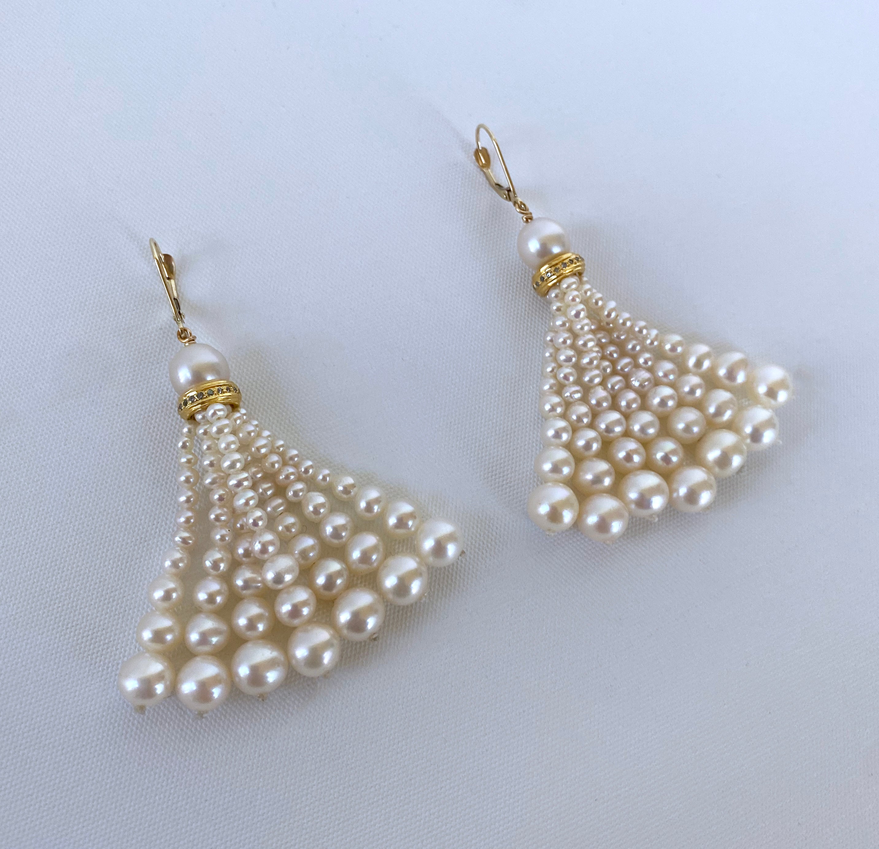 Beautiful pair of earrings by Marina J. This pair features wonderful round Pearls sitting atop a Diamond encrusted Gold roundel from which multi strands of Graduated Cultured Pearls hang. The encrusted Diamonds magnificently shine and elevate this