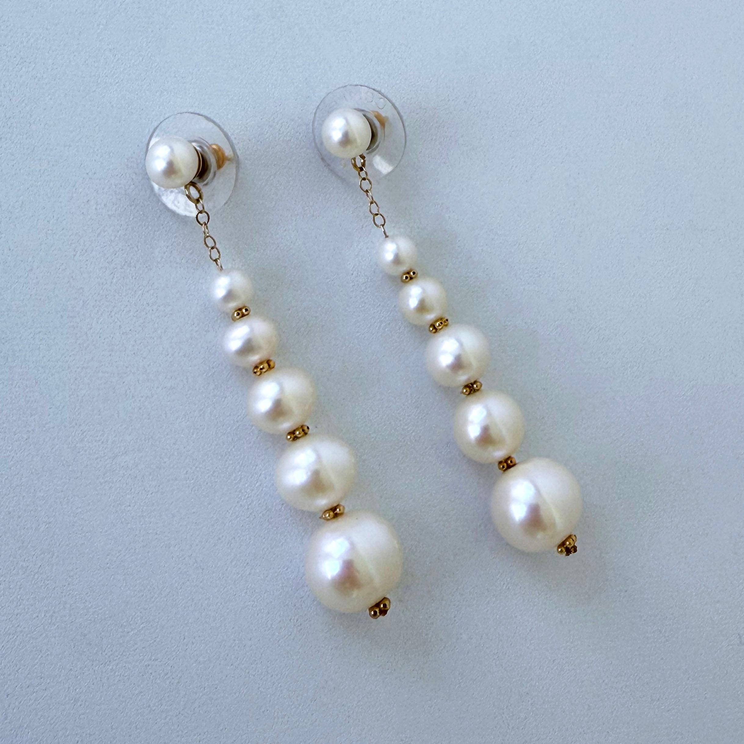 Beautiful pair of Earrings by Marina J.

This pair features a Pearl stud from which solid 14k Yellow Gold Chain hangs, dangling with it a strand of Graduated Pearls all adorned with Solid 14k Yellow Gold beads in-between.  Measuring 1.5 inches long,
