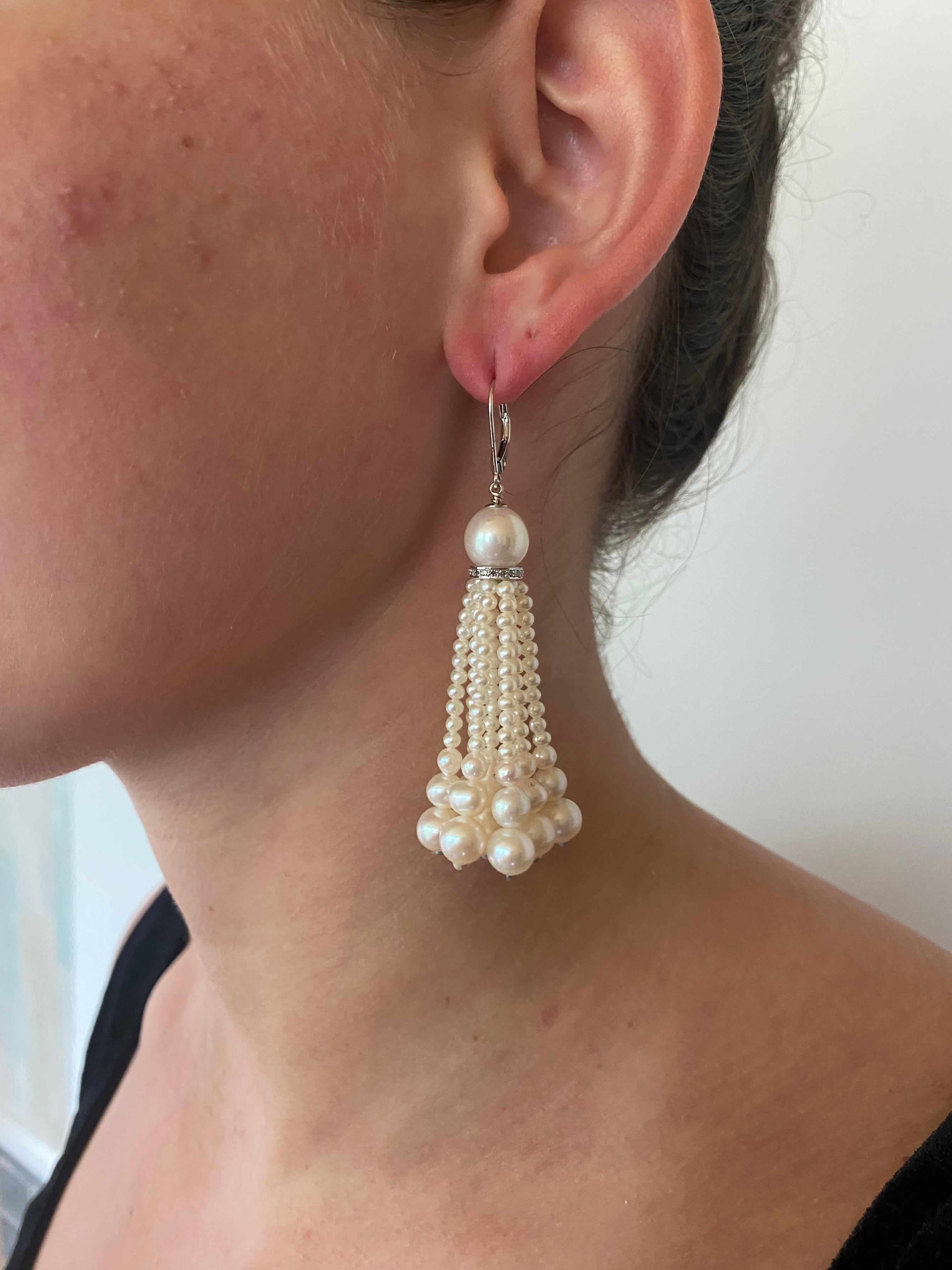 Simple yet gorgeous pair of Earrings by Marina J. Each Earring features a round Pearl sitting atop a Diamond encrusted roundel from which multiple strands of Graduated Pearls hang. The White Gold perfect accents the luster of the Pearls while the