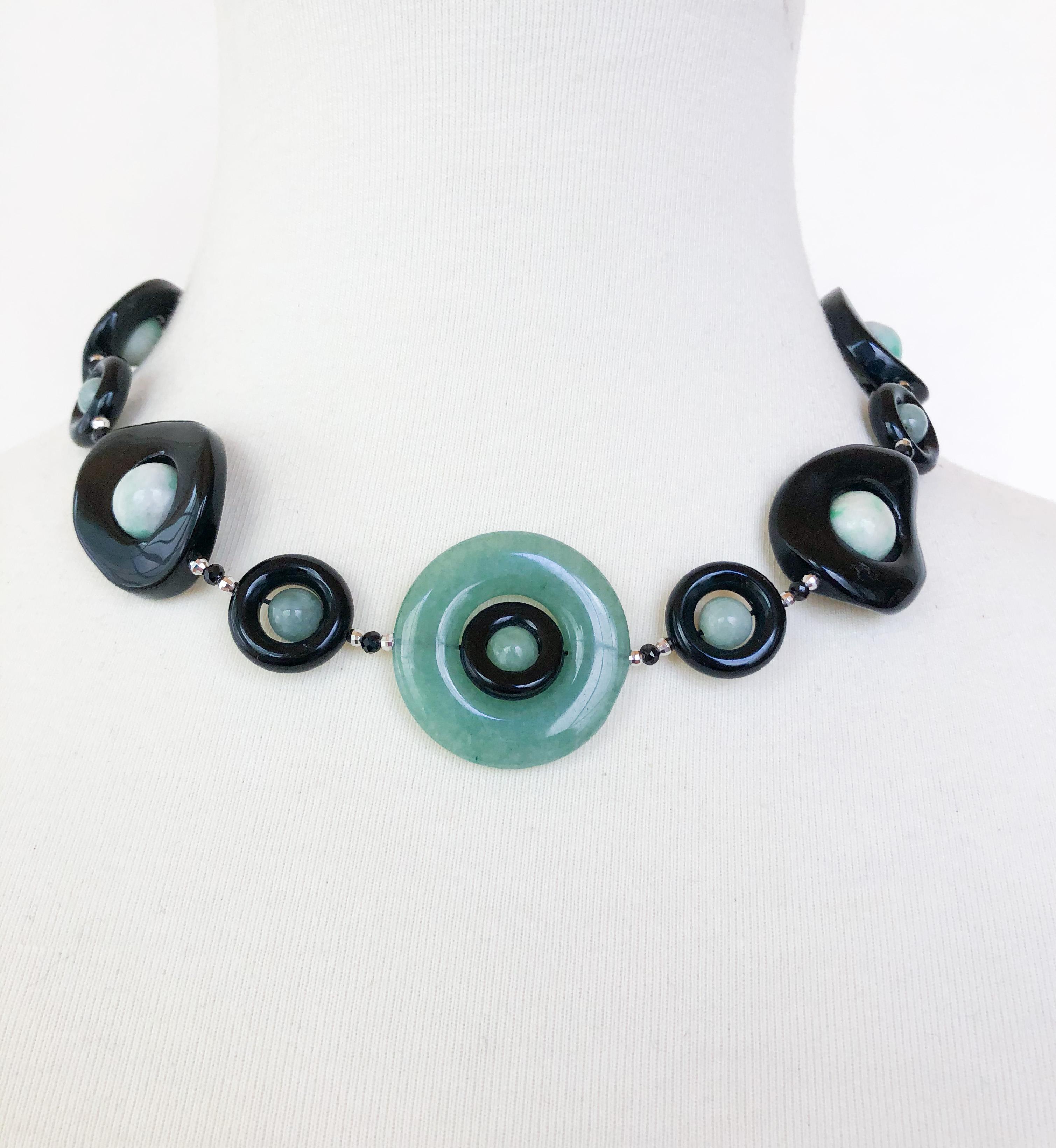 This necklace is made of jade and black onyx, with tiny black spinel and silver beads in between. The center of the necklace features a large jade ring, a small onyx ring, and a small circular jade bead. The rest of the necklace is composed on