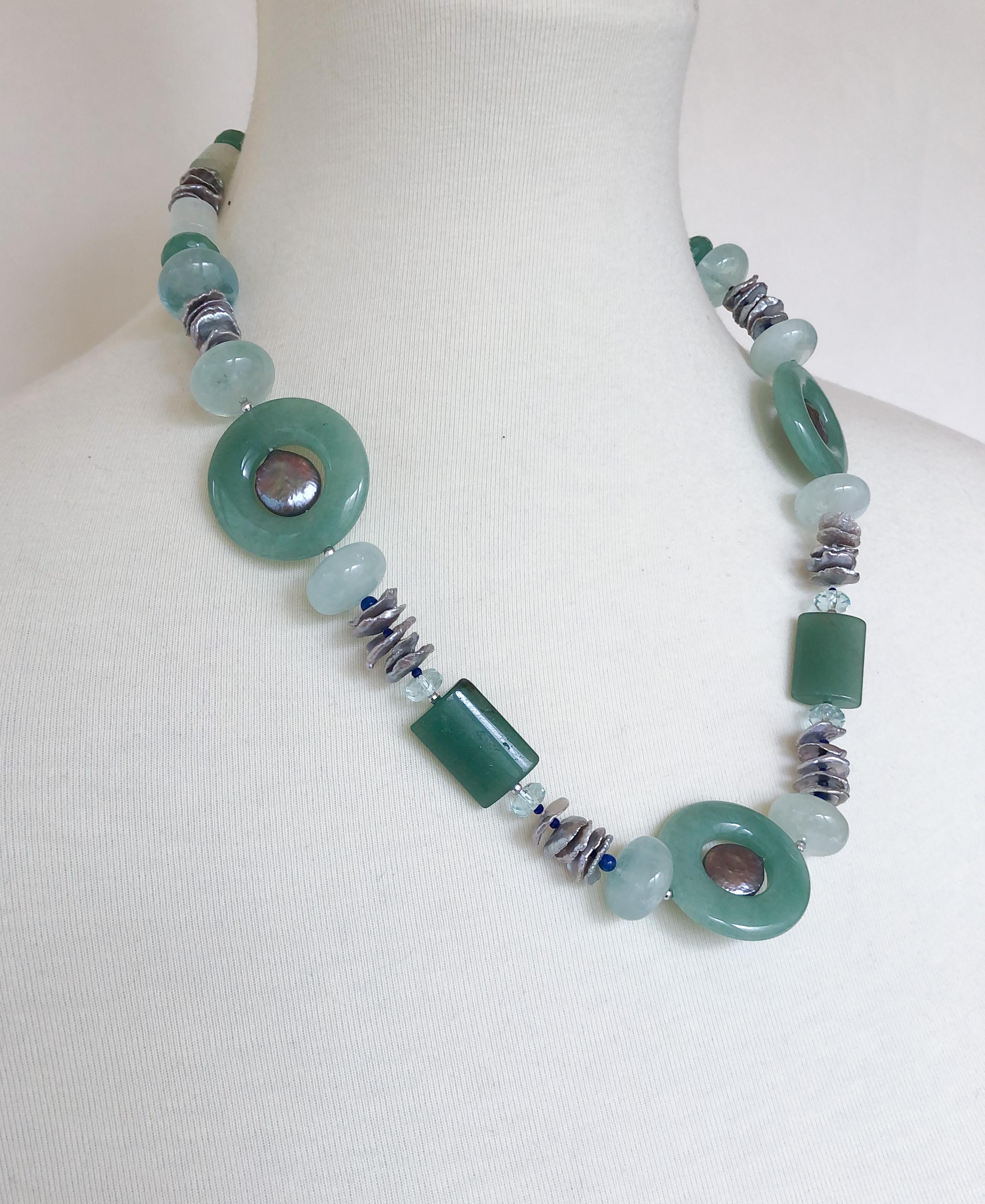 Diese Halskette besteht aus einem Jadering und Jadesteinen, Aquamarinsteinen und grünen Aventurinsteinen. Das prächtige Grün dieser Halskette wird durch graue Süßwasserperlen und winzige Lapislazuli-Perlen kontrastiert, die einen Farbakzent setzen.