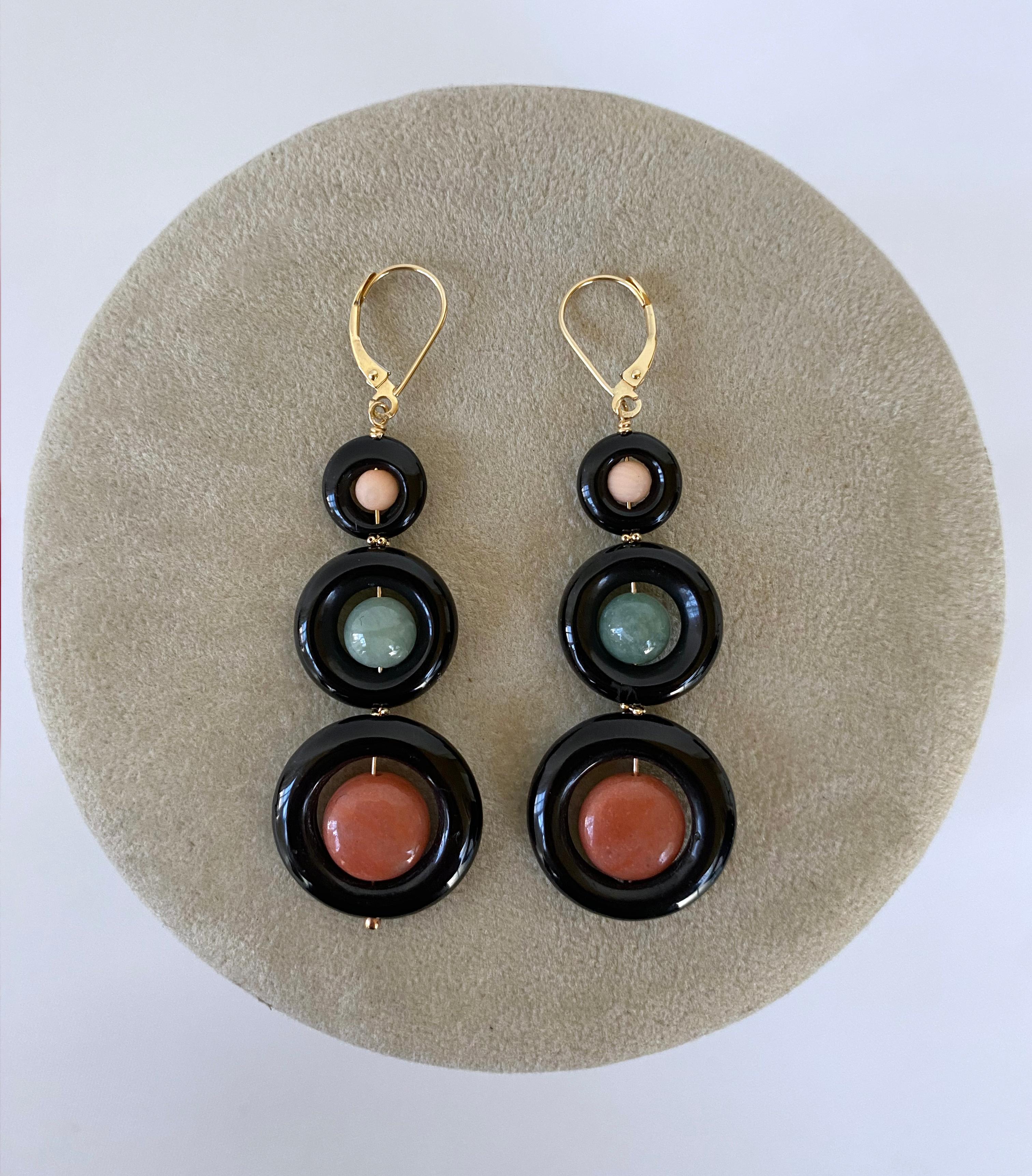 Gorgeous and bold pair of earrings by Marina J. This pair features three graduating Black Onyx rings hanging from solid 14k Yellow Gold Wire. The top and bottom Rings carry beautiful pink colored Flat Coin Corals and the middle displays a round