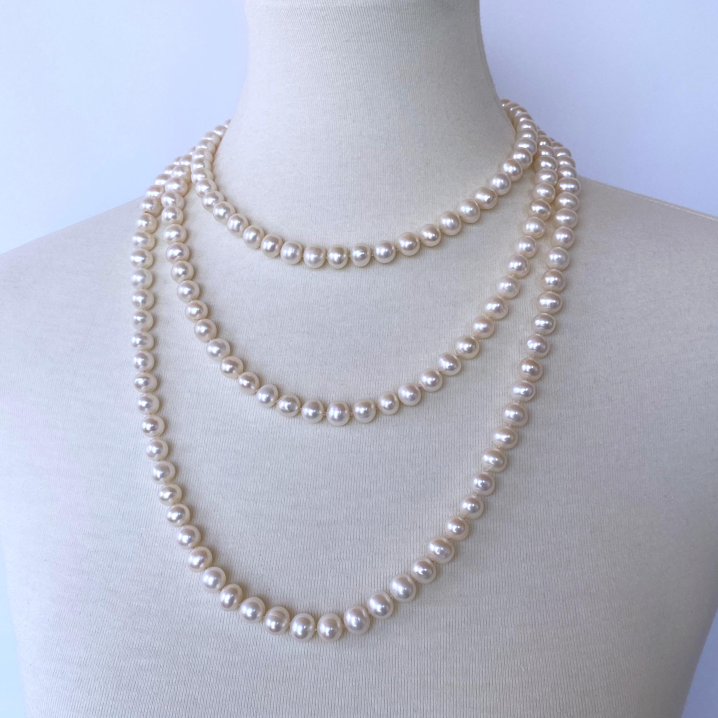 Gorgeous long knotted Pearl necklace by Marina J. This beautiful piece features all Cultured White, which display great sheen and iridescence. Measuring 60 inches long, this necklace meets at a solid 14k Yellow Gold Ball clasp, which perfectly