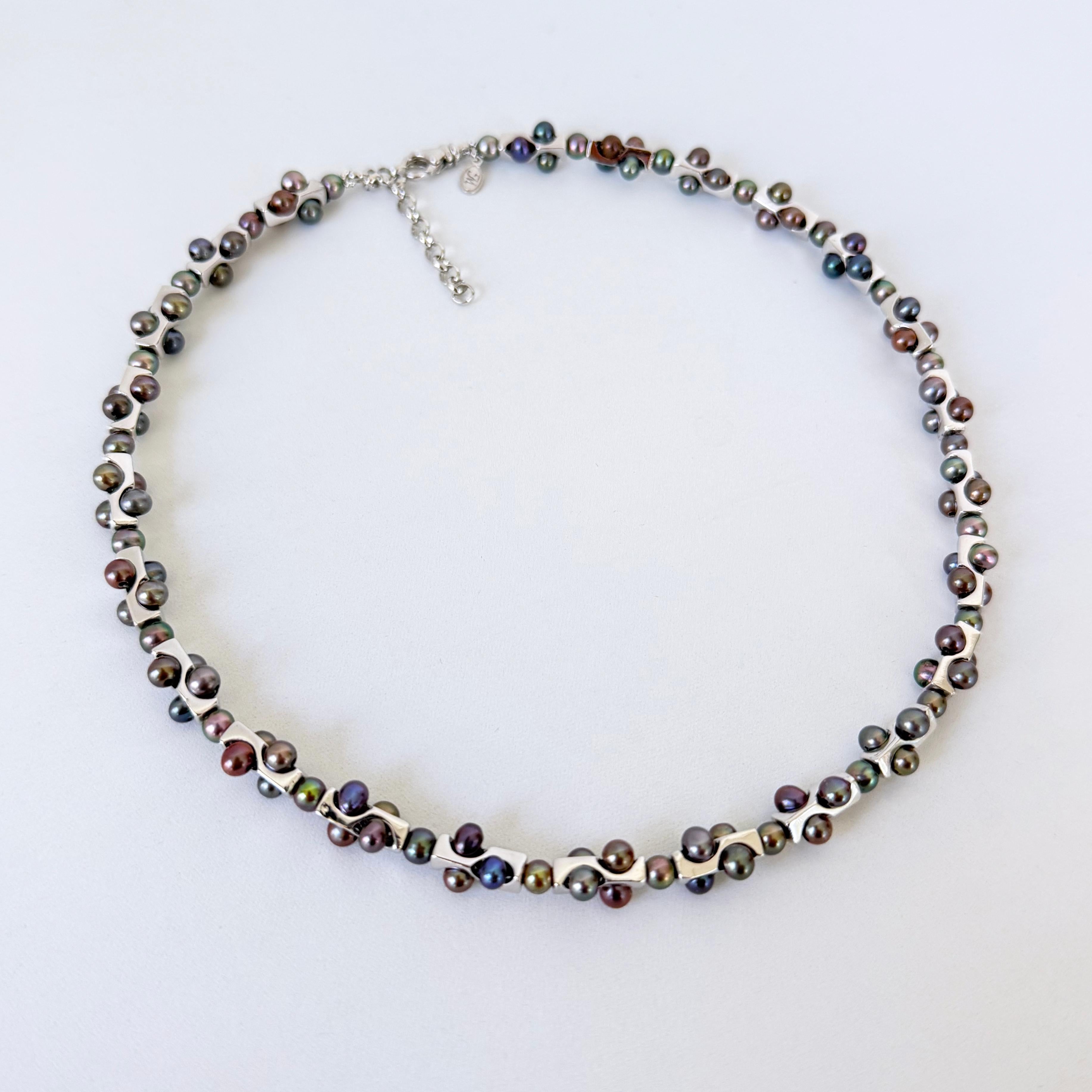 Questa collana unica nel suo genere è realizzata con perline geometriche in argento fuso e rodiato di Marina J., contrastate e impreziosite da perle nere ad alta lucentezza. Le perle nere hanno una lucentezza e una brillantezza multicolore, con