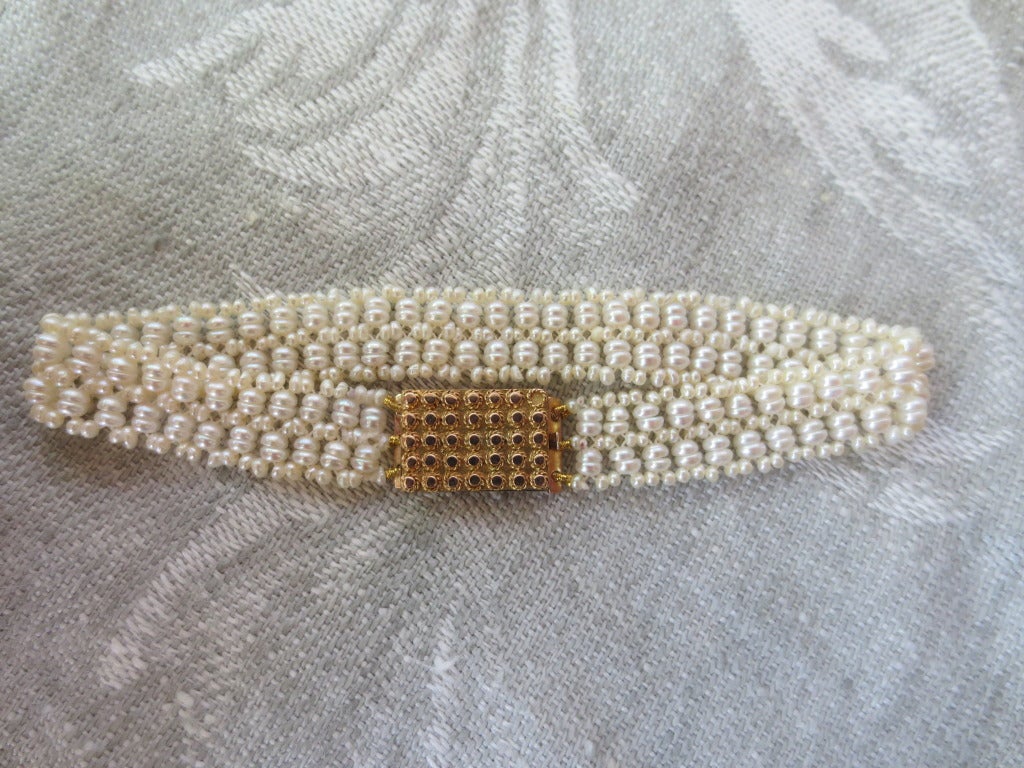 Antique Victorian gold clasp is transformed into a unique and simply elegant bracelet. The clasp is made from 14k gold and engraved with the name Marione dating back to the late 19th century. Tiny seed pearls are delicately hand-woven creating a