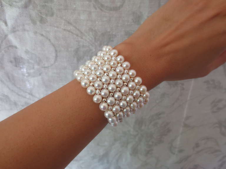 The intricate handwoven multi-strand wide pearl cuff bracelet is accented with rhodium plated silver faceted beads and clasp. The glowing white pearls are 3 mm and 6 mm in size. The bracelet measures 6.75 