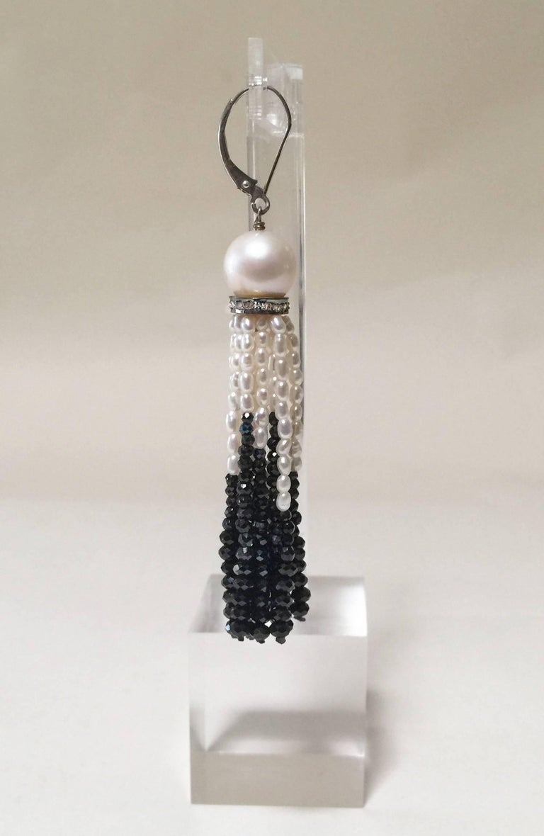 These elegant earrings start with a large 9 mm pearl, followed by a diamond-encrusted silver roundel. The tassel is composed of luminous 