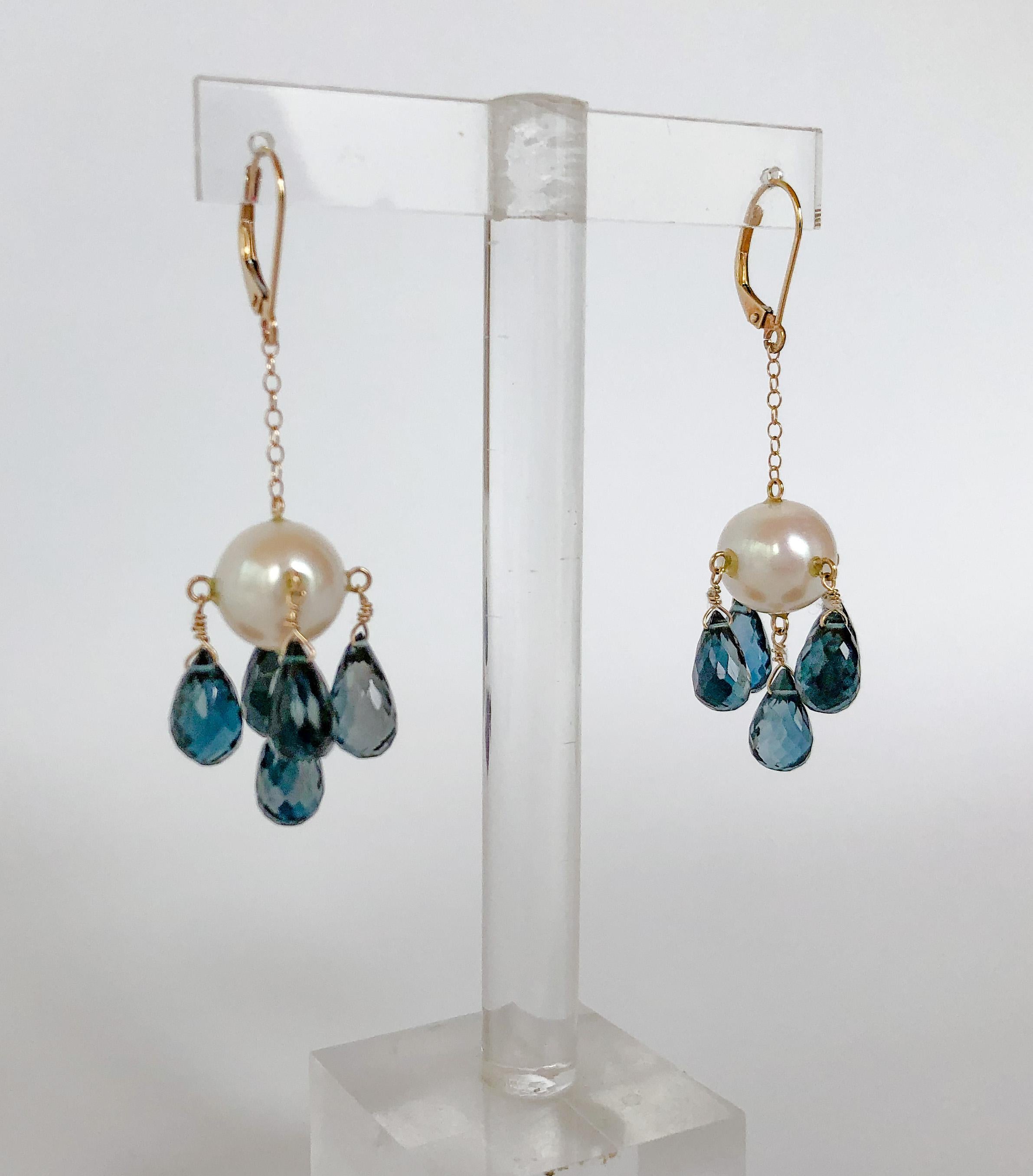 These eye-catching earrings are made with a large cultured pearl and 5 teardrop London blue topaz beads. The topaz is sure to stand out whenever it catches the light. The wiring and lever-backs are made with 14k yellow gold, which is sturdy and