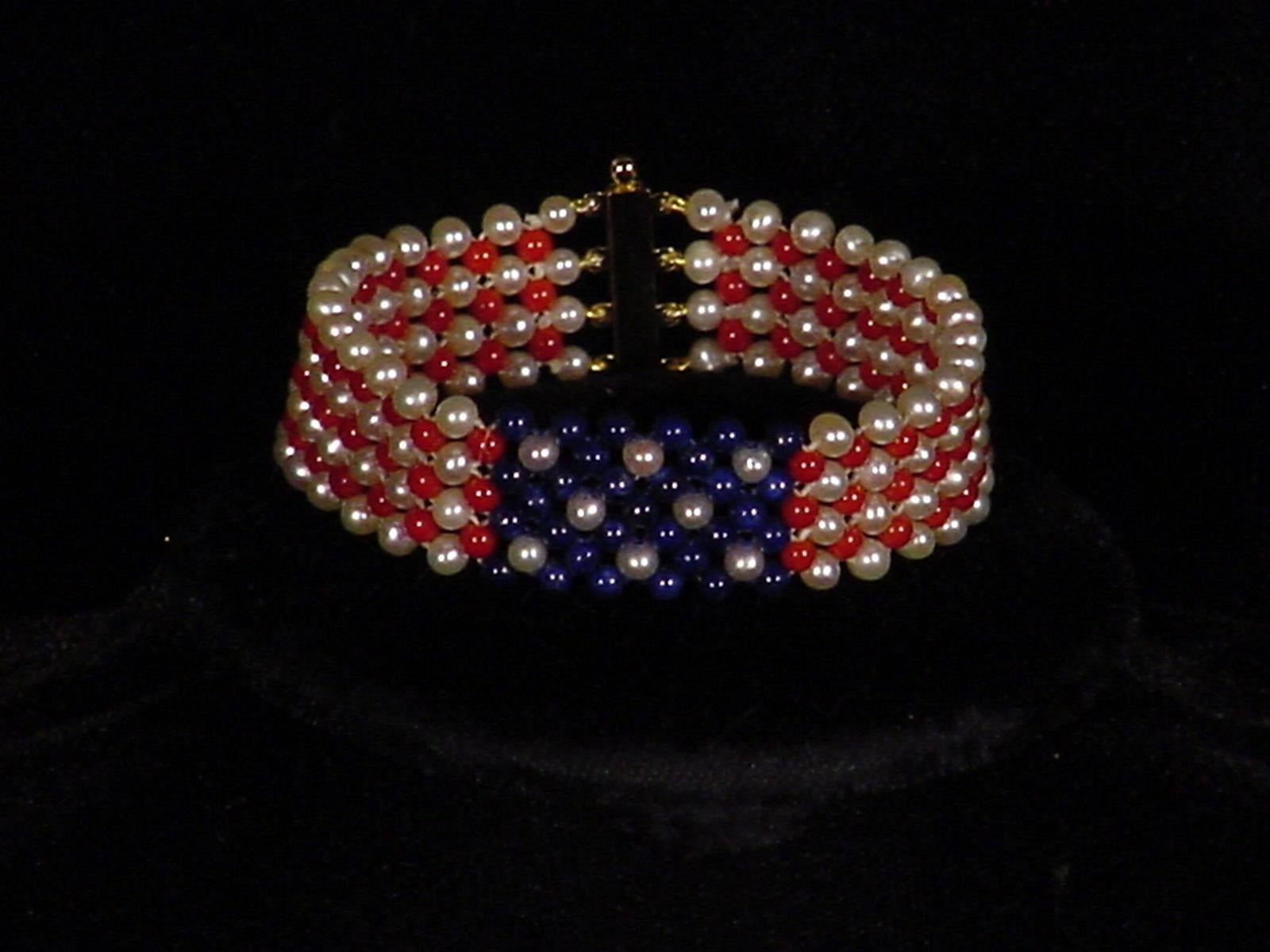 Gorgeous hand woven bracelet by Marina J. This piece features high luster Pearls, Coral and Lapis Lazuli woven together to create a beautiful American Flag design. Using 2.5 - 3mm sized beads, this bracelet measures 6.75 inches and meets at a secure