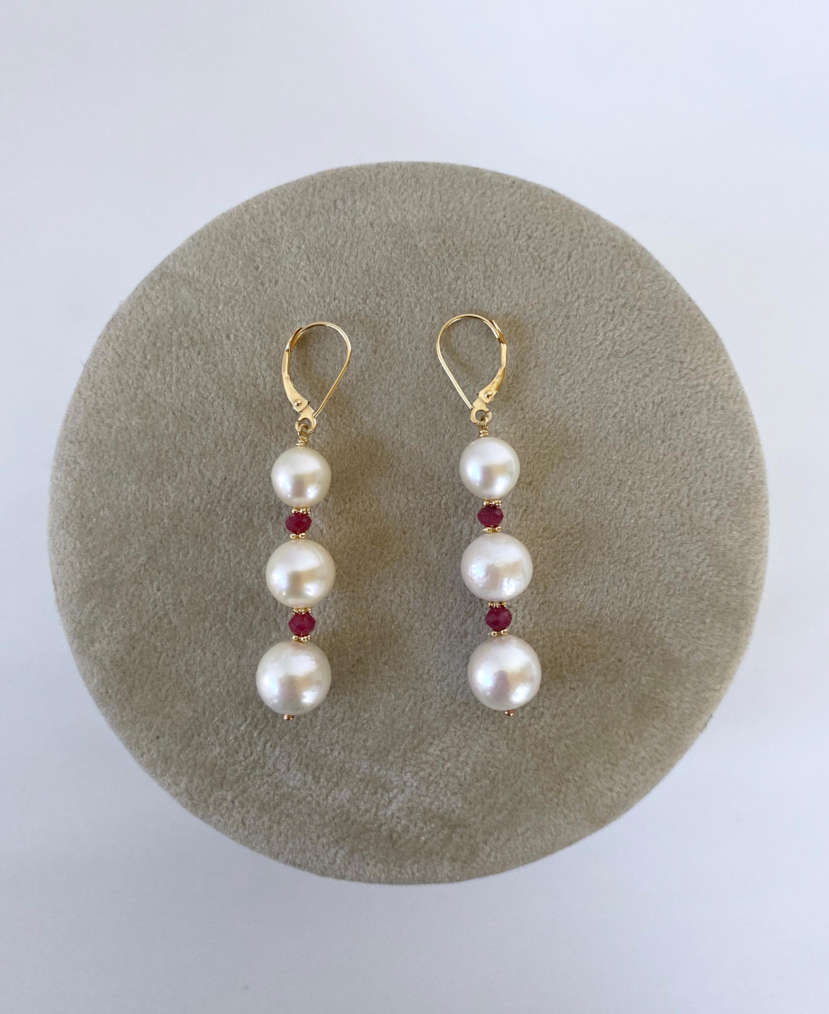 Gorgeous pair of earrings by Marina J. This pair features high luster Pearls with soft iridescence, adorned by striking Rubies and solid 14k Yellow Gold findings! The Rubies display a beautiful Soft Red/Pink color and their semi translucence allows