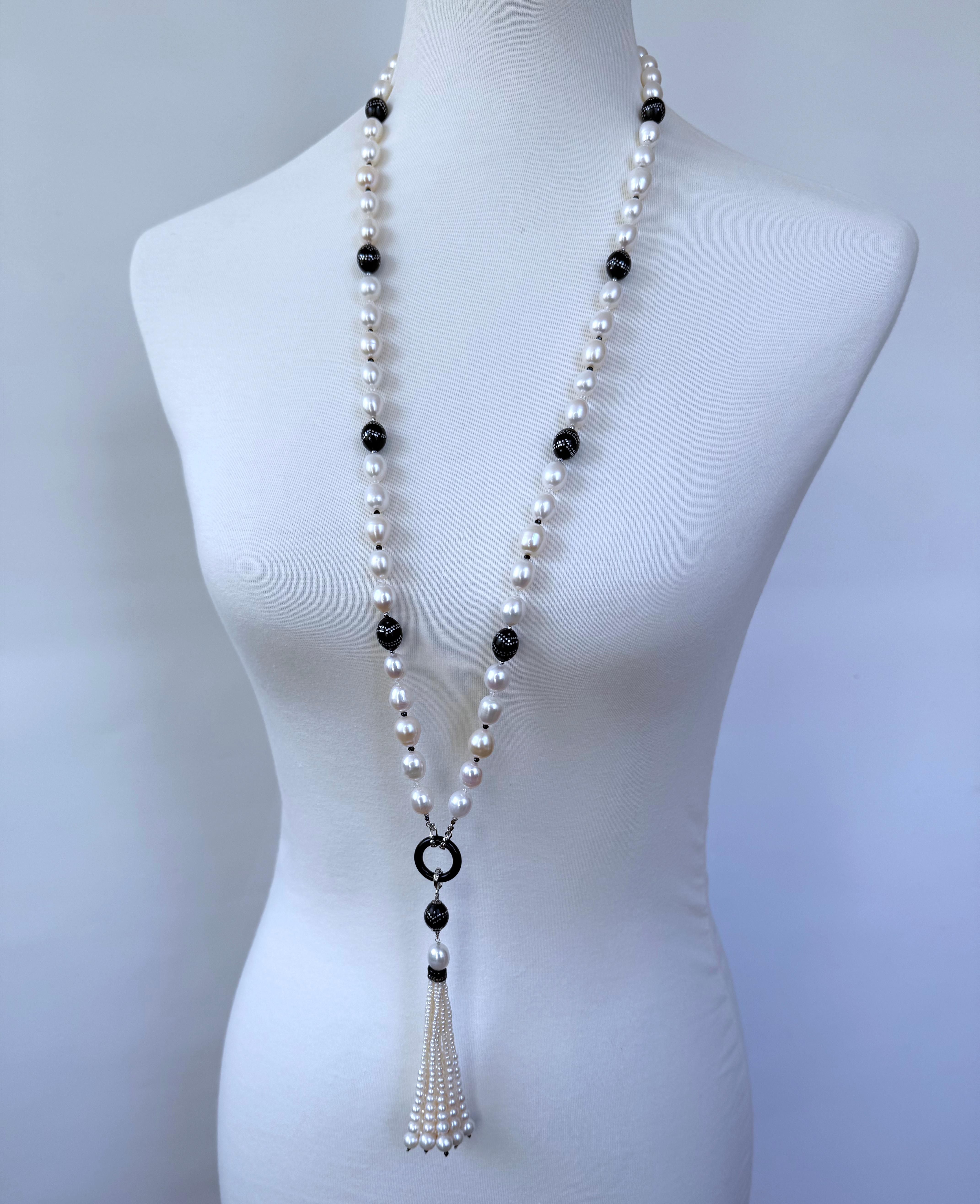 Questo pezzo è realizzato con perle ovali dalla morbida lucentezza iridescente, infilate insieme a perline Worry vintage intarsiate in ebano e argento. Con una lunghezza di 35 pollici, entrambe le estremità di questo Sautoir si incontrano con ganci