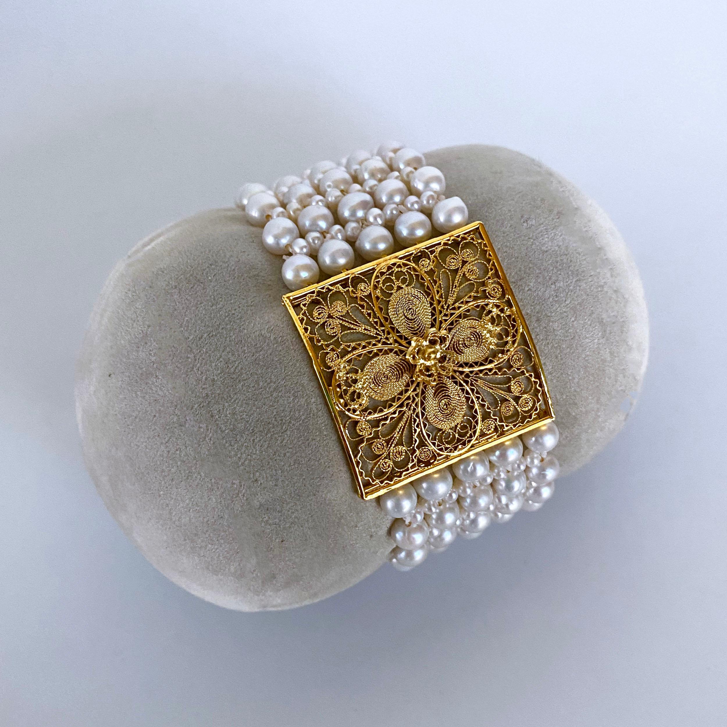 Gorgeous One of A Kind piece by Marina J. This bracelet is made of multi sized cultured white Pearls all intricately woven together into a fine lace like design. This piece features a Floral Filigree Square 18k Yellow Gold Plated Silver Centerpiece.