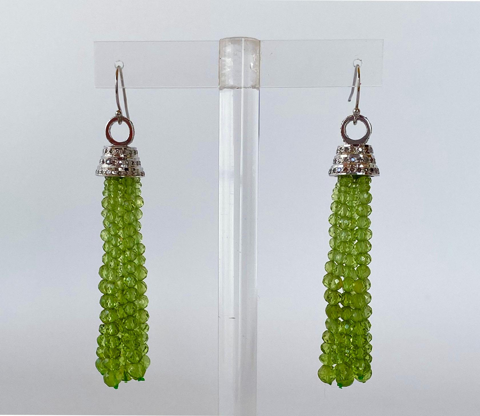 These beautifully crafted and slightly graduated Peridot tassel earrings are made of faceted 1.5mm - 2mm beads. The tassel hangs from a Silver Rhodium plated Cup with encrusted diamonds, offering a light and luxurious feel. Ear wires are made of 14k