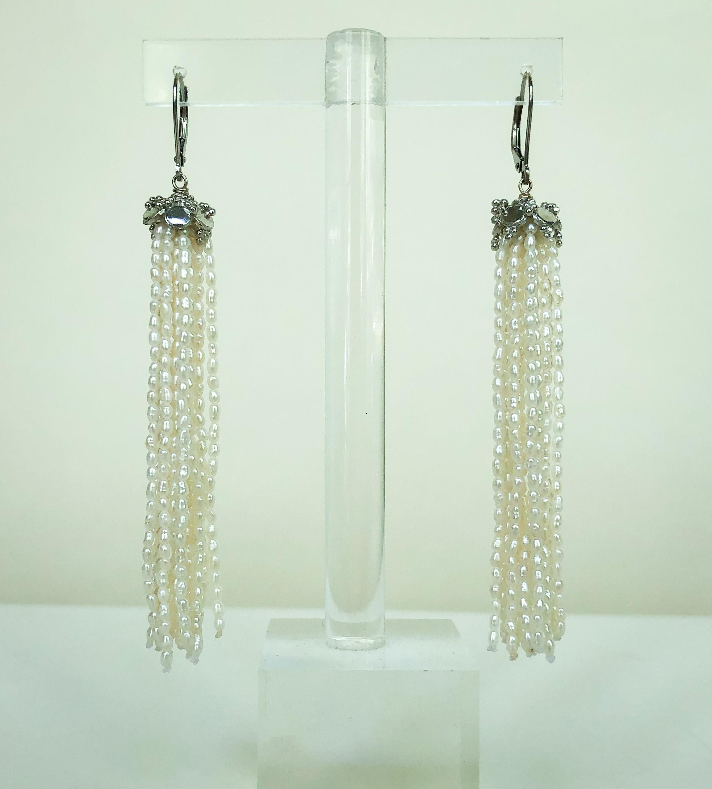These white rice pearl tassel earrings with 14k white gold lever-backs with a silver rhodium-plated cup are lush and elegant. Flowing out of the roundel are strands of beautiful white rice pearls. At almost 3.5 inches inches, these earrings are