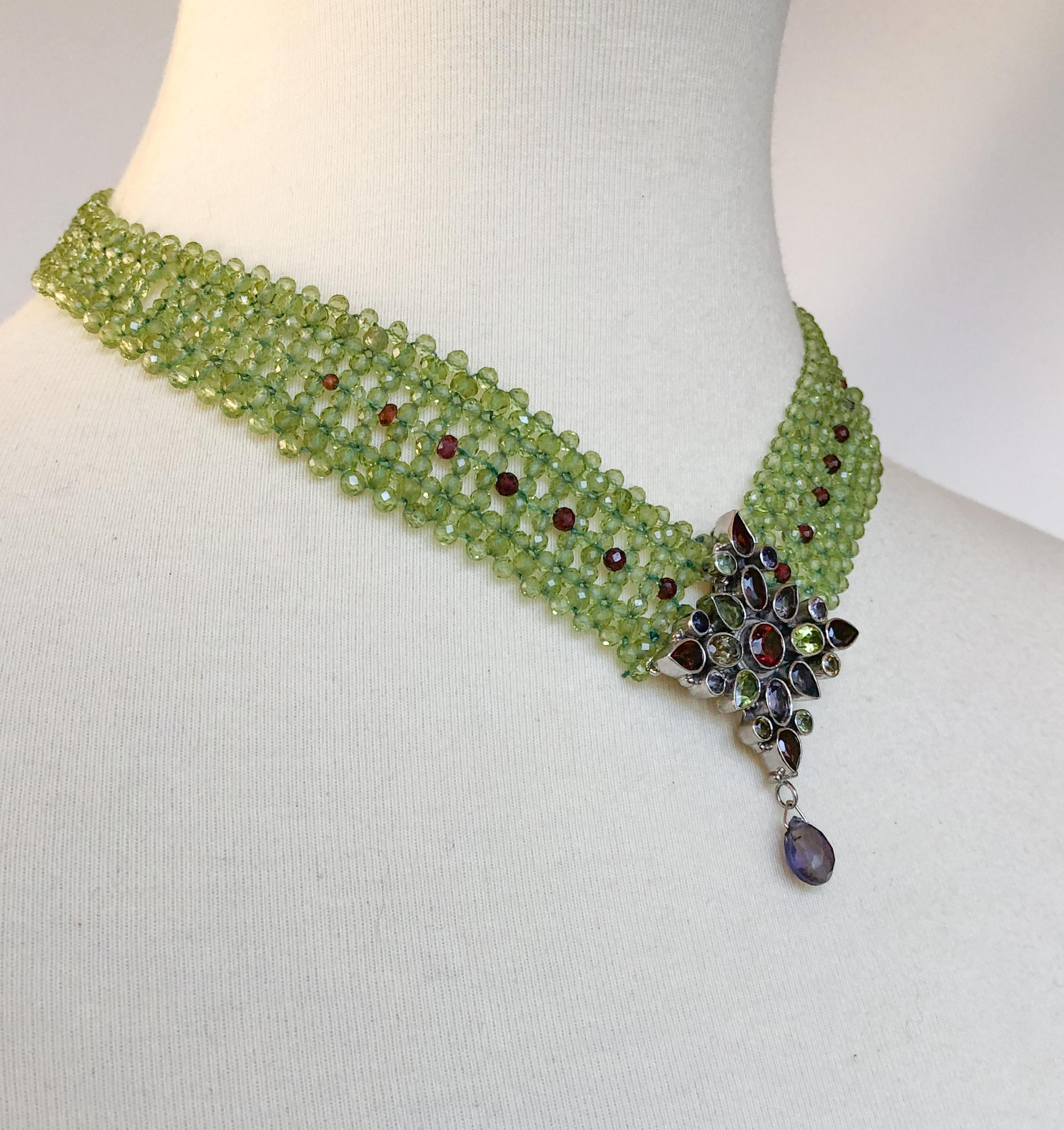 This beautiful necklace is hand woven with different sized peridot beads and some graduated garnet beads to match the centerpiece. The rhodium plated silver centerpiece is made with peridot, garnet, iolite and kyanite, with a small kyanite drop