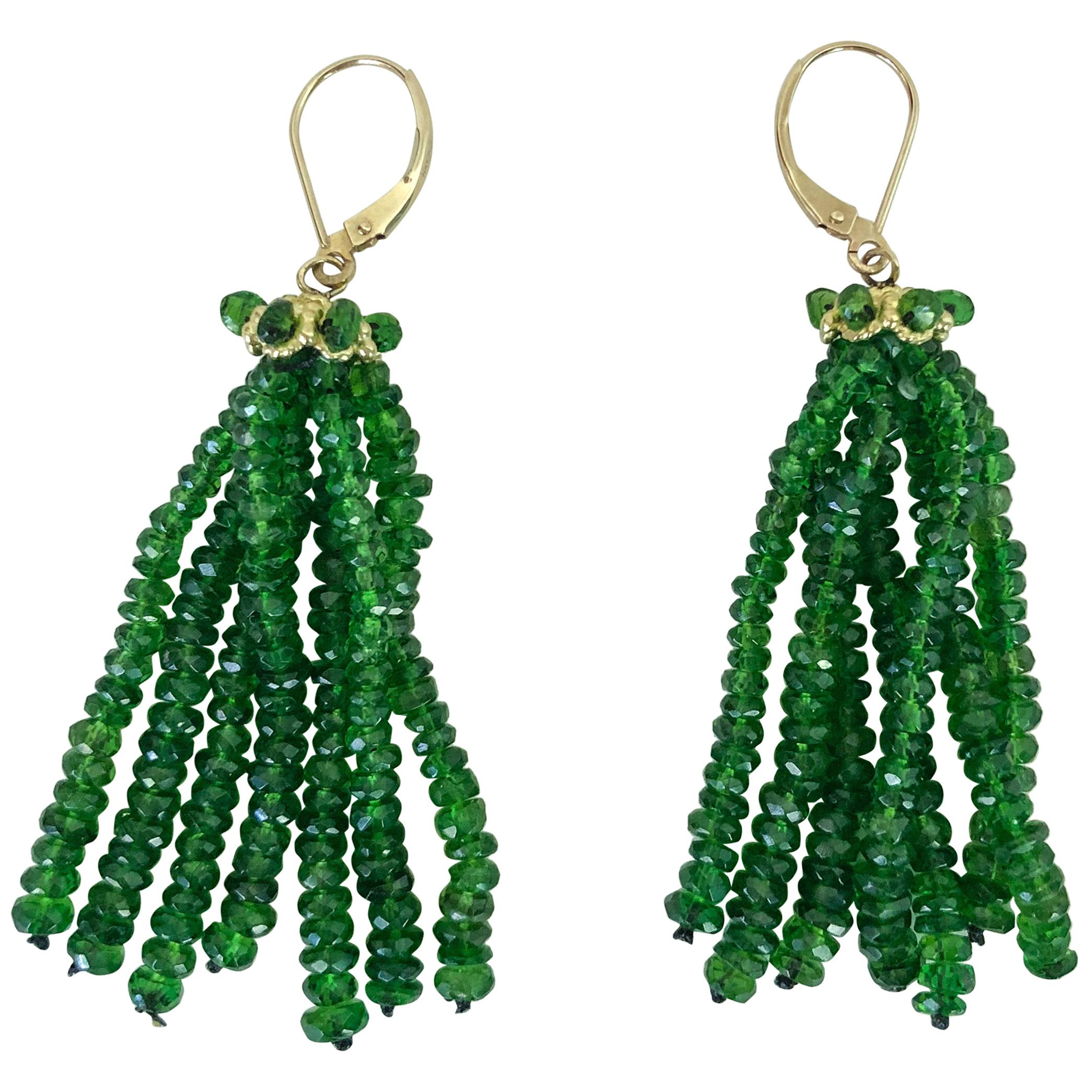 These elegant tassel earrings by Marina J. are made with stunning 4mm tsavorite beads. The earring is topped with a unique 14k gold cup that is adorned with tsavorite beads. The lever backs are made of 14k gold. These earrings are about two inches