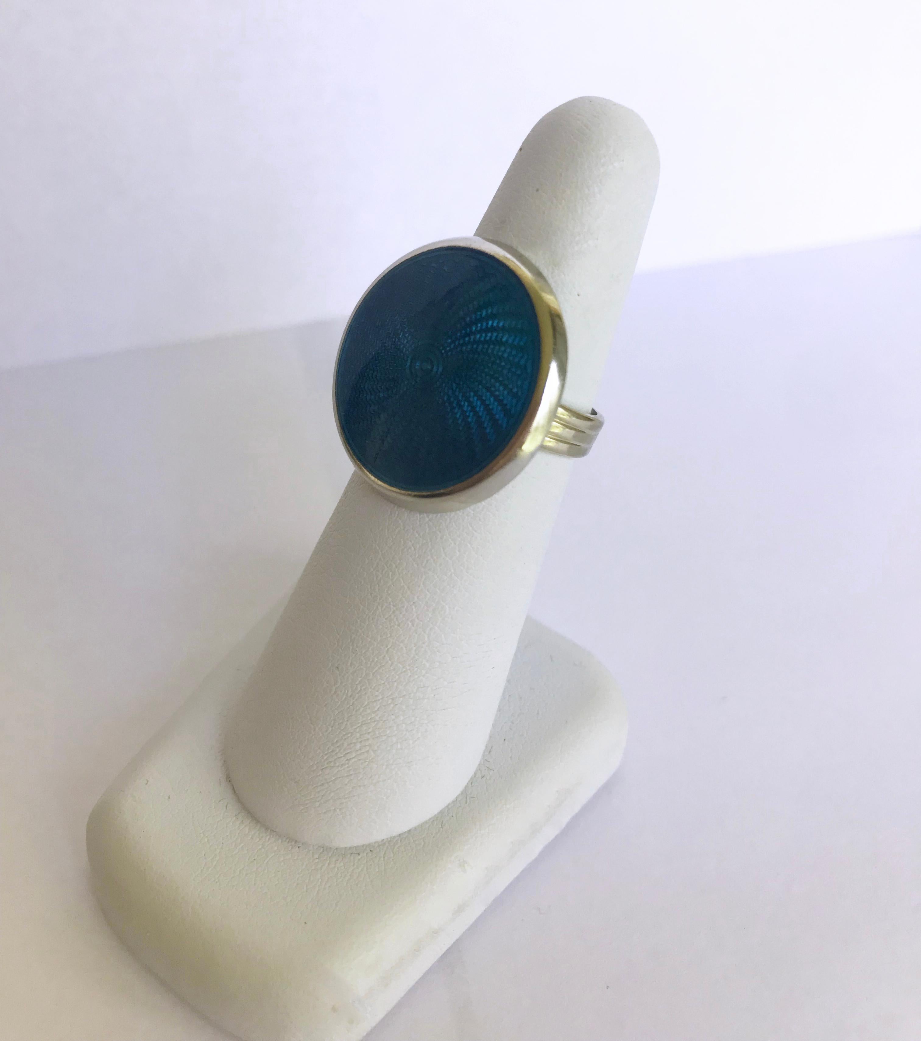 Marina J. created this stunning piece with a vibrant turquoise color enameled circle on the front, glimmering sterling silver around it, and 14 karats white gold for the ring band. The enamel is approximately 20mm by 20mm and the width of the ring