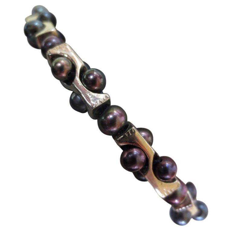 Bracciale geometrico di Marina J. 
Questo braccialetto è realizzato con tutti  Perline in argento placcato oro bianco 14 k e perle nere. 
Le perle nere mostrano una lucentezza multicolore simile a quella di una marea nera, che si sposa perfettamente