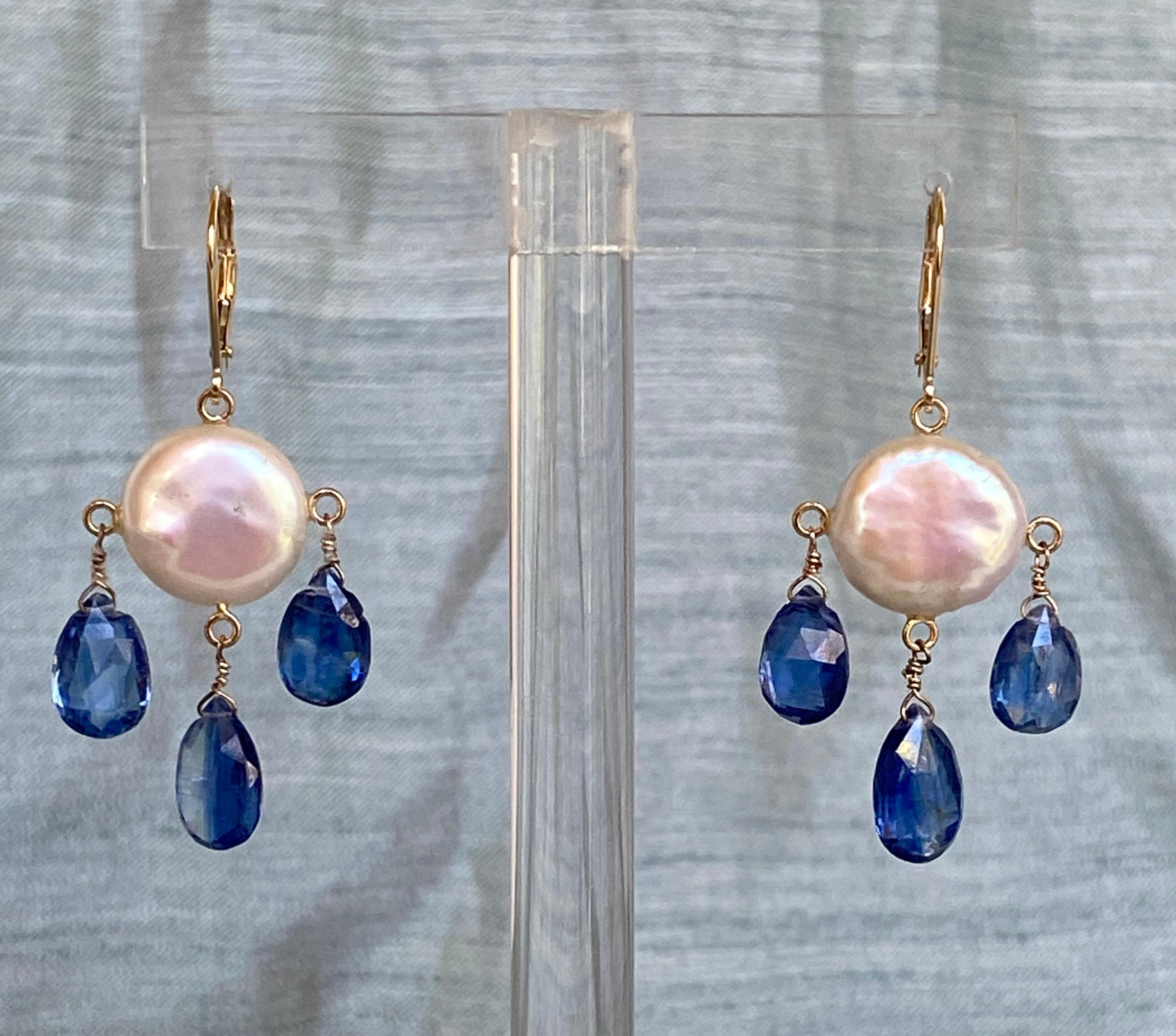 These white coin pearl and kyanite drop earrings with 14k yellow gold lever-backs and findings are strikingly beautiful. The deep royal blue faceted kyanite drops harmoniously hang with a glowing white coin pearl. These earrings are held together