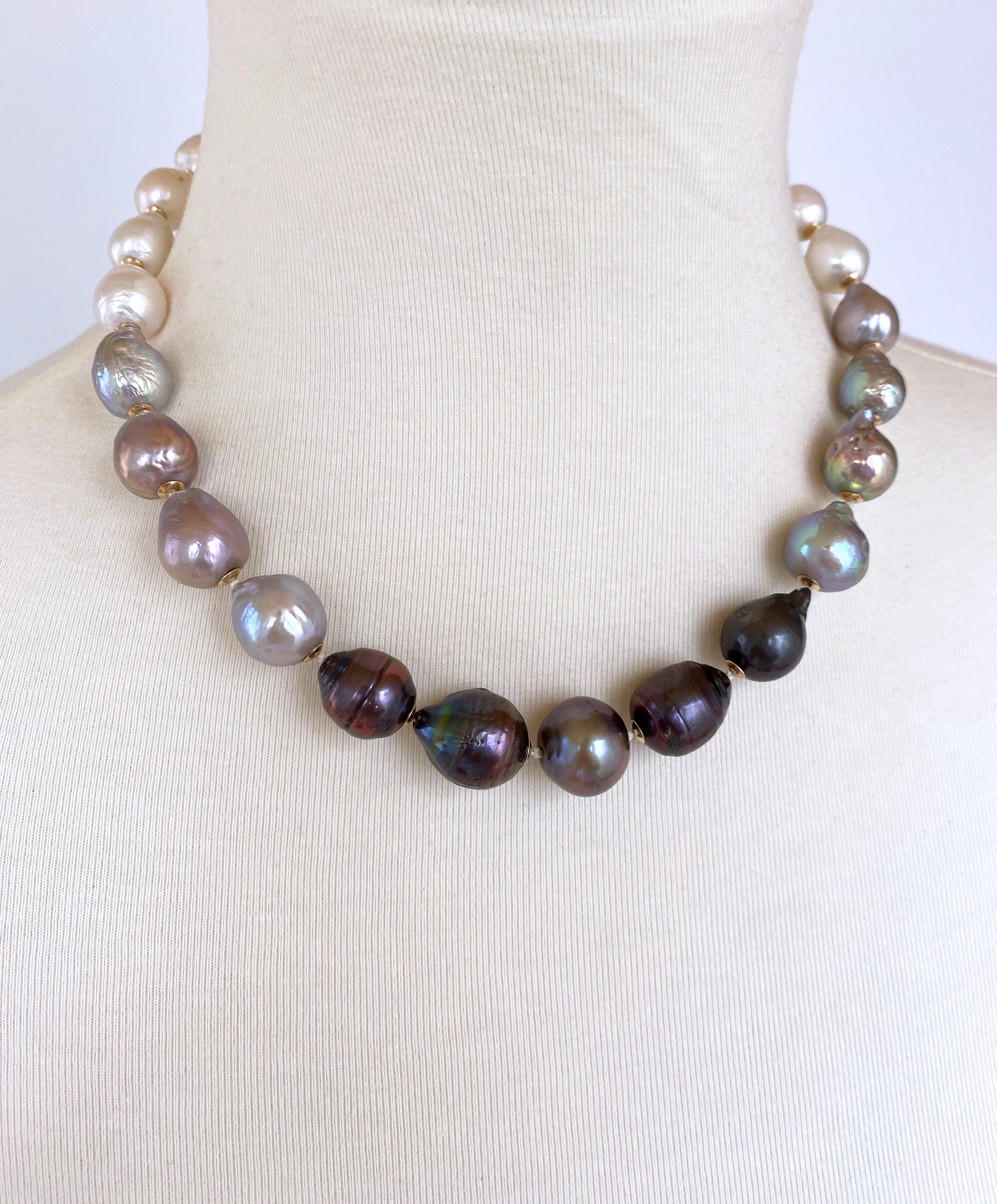 This classic, elegant necklace is made with white, grey and black baroque pearls. The pearls are graduated as the necklace transitions from the darker pearls to the white pearls. The pearls are adorned with 14k yellow gold cups that match the sturdy