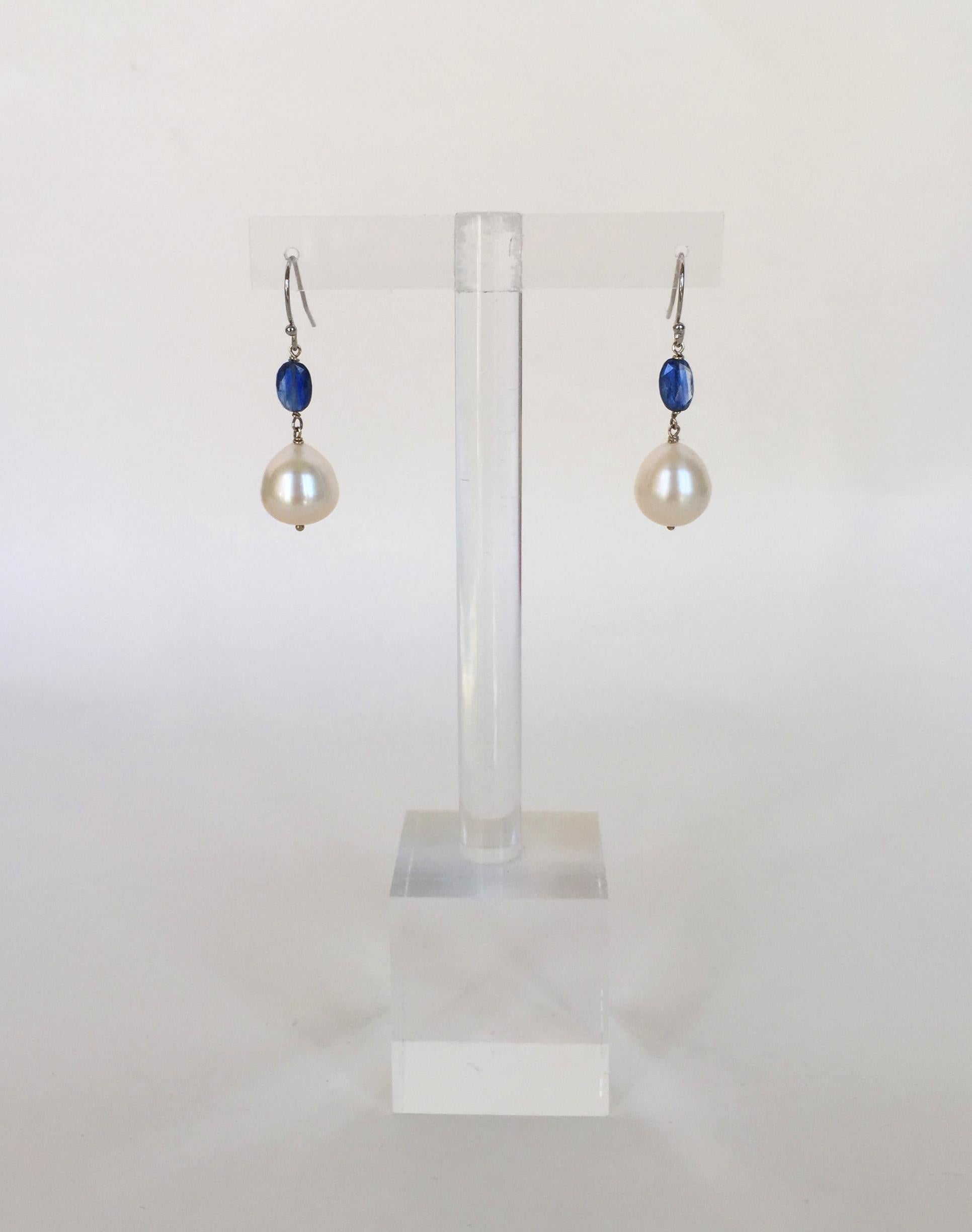 These white pearl and kyanite drop earrings with 14k white gold hooks are striking for the white and blue contrast. The glowing teardrop white pearl is made more studding with the deep blue kyanite faceted bead. These earrings are a twist on the