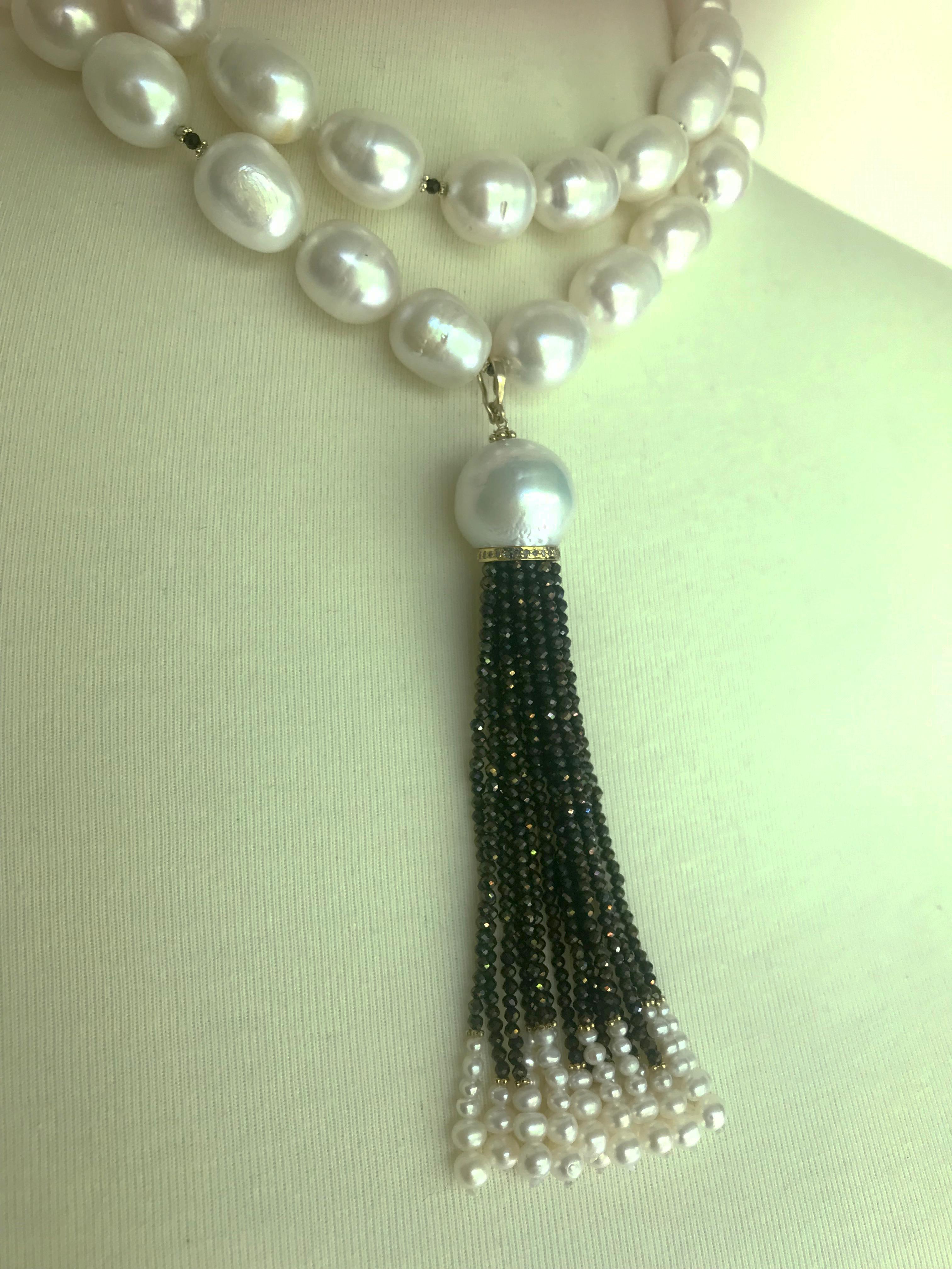 This magnificent sautoir is made from large baroque pearls with a removable tassel and 14k yellow gold clasp and beads. The beautiful tassel is composed of a large baroque pearl, resting on a diamond-encrusted 14k yellow gold roundel follow by black