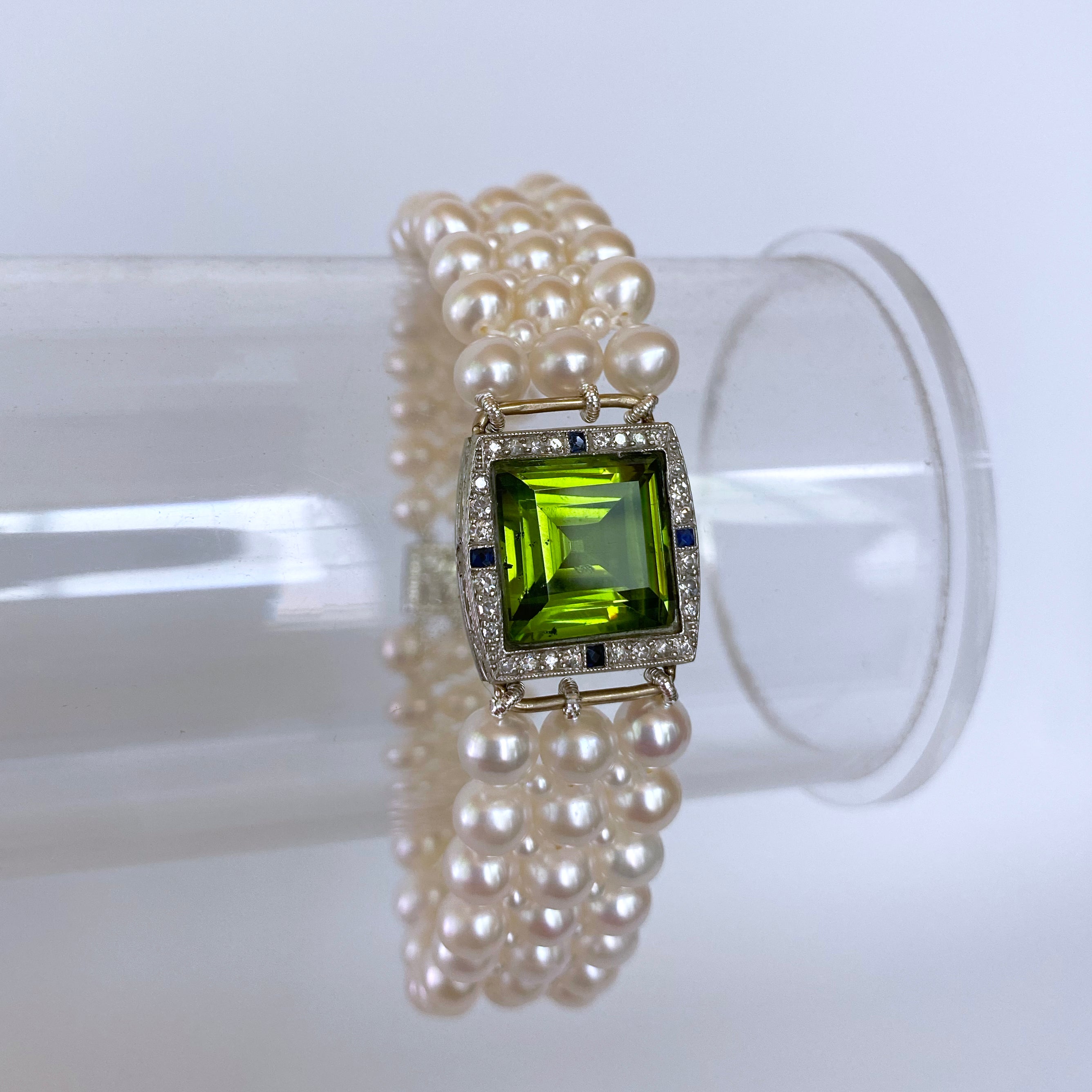 Beautiful piece by Marina J. This bracelet features a one of a kind Antique 14k White Gold and Diamond Encrusted watch that has been reworked into a gorgeous centerpiece. A large 'emerald cut' Peridot stone sits in the middle of the reworked watch,