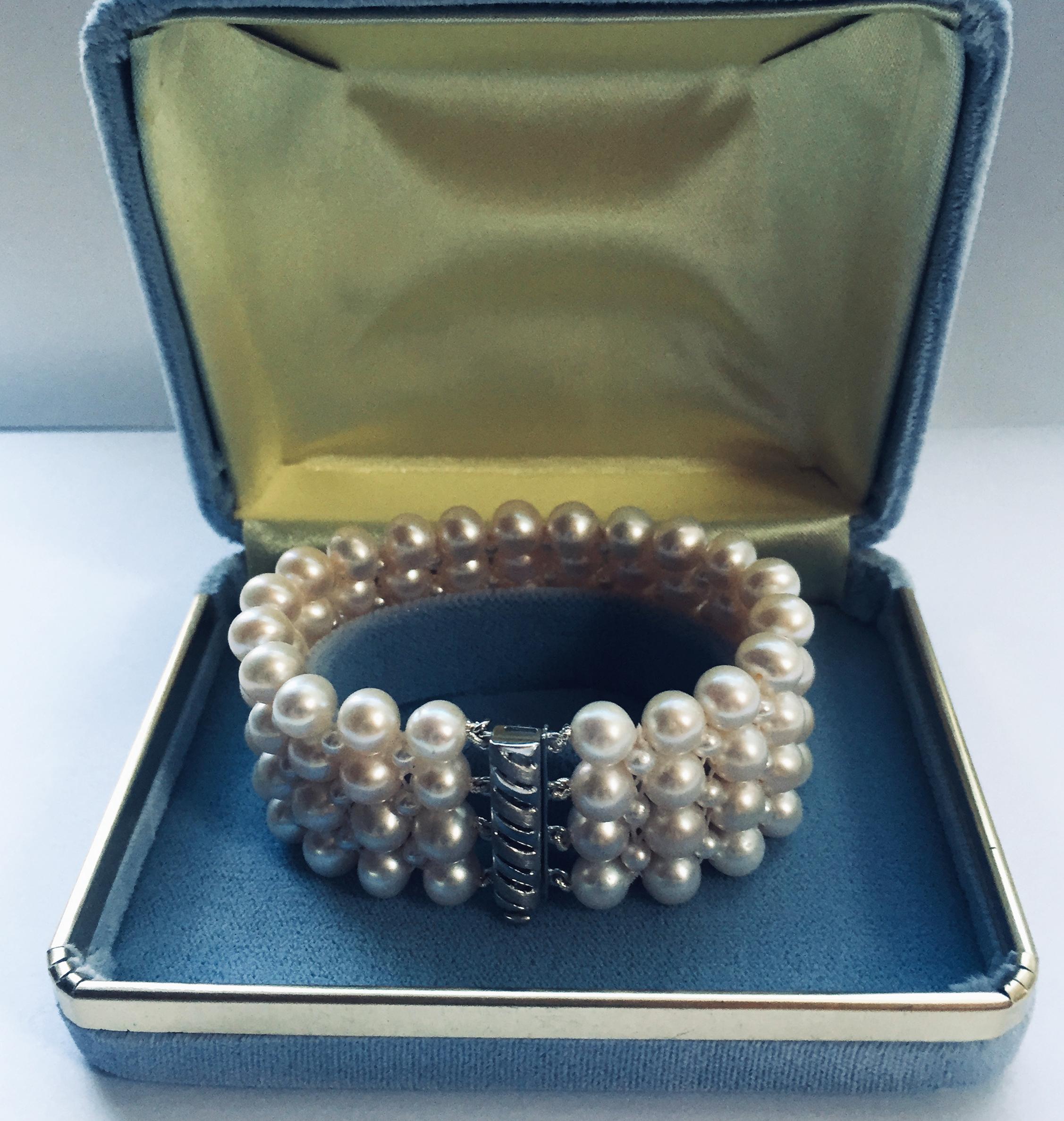 This beautiful, classic, and timeless bracelet has an elegant pearl weave. At a 1 inches, wide the different size pearls (5mm to 2mm) create a checkered design with 14k white gold plated clasp. It is easy to use and secure once fitted on the wrist.