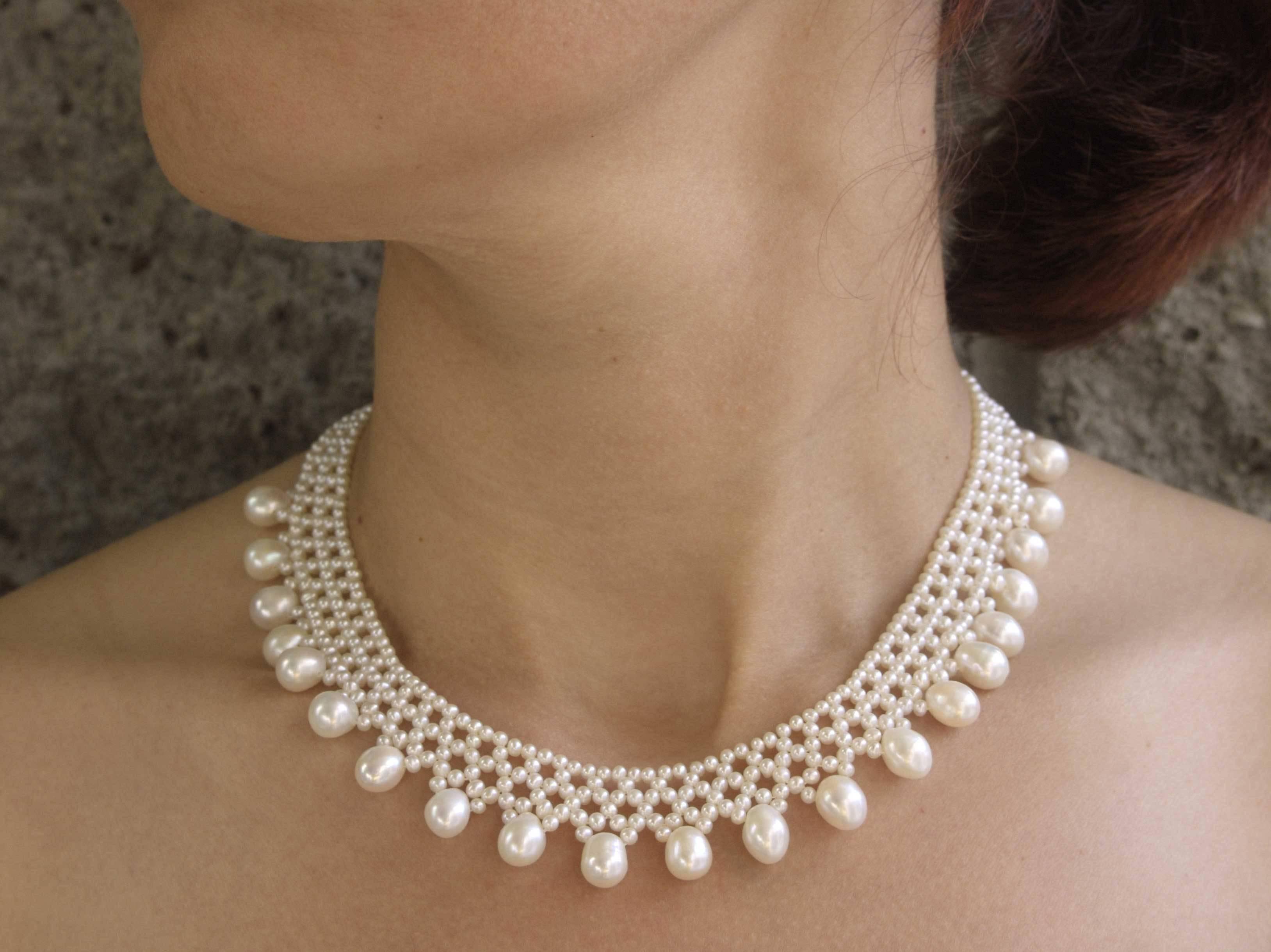 This hand woven necklace is made using 2.5-3 mm pearls to create a lace-like design that perfectly fits the collar.         ( 16.5 inches  long) . Necklace is tapered in design to fit along the curve of the neckline. 6.5 - 7 mm pear-shaped drops