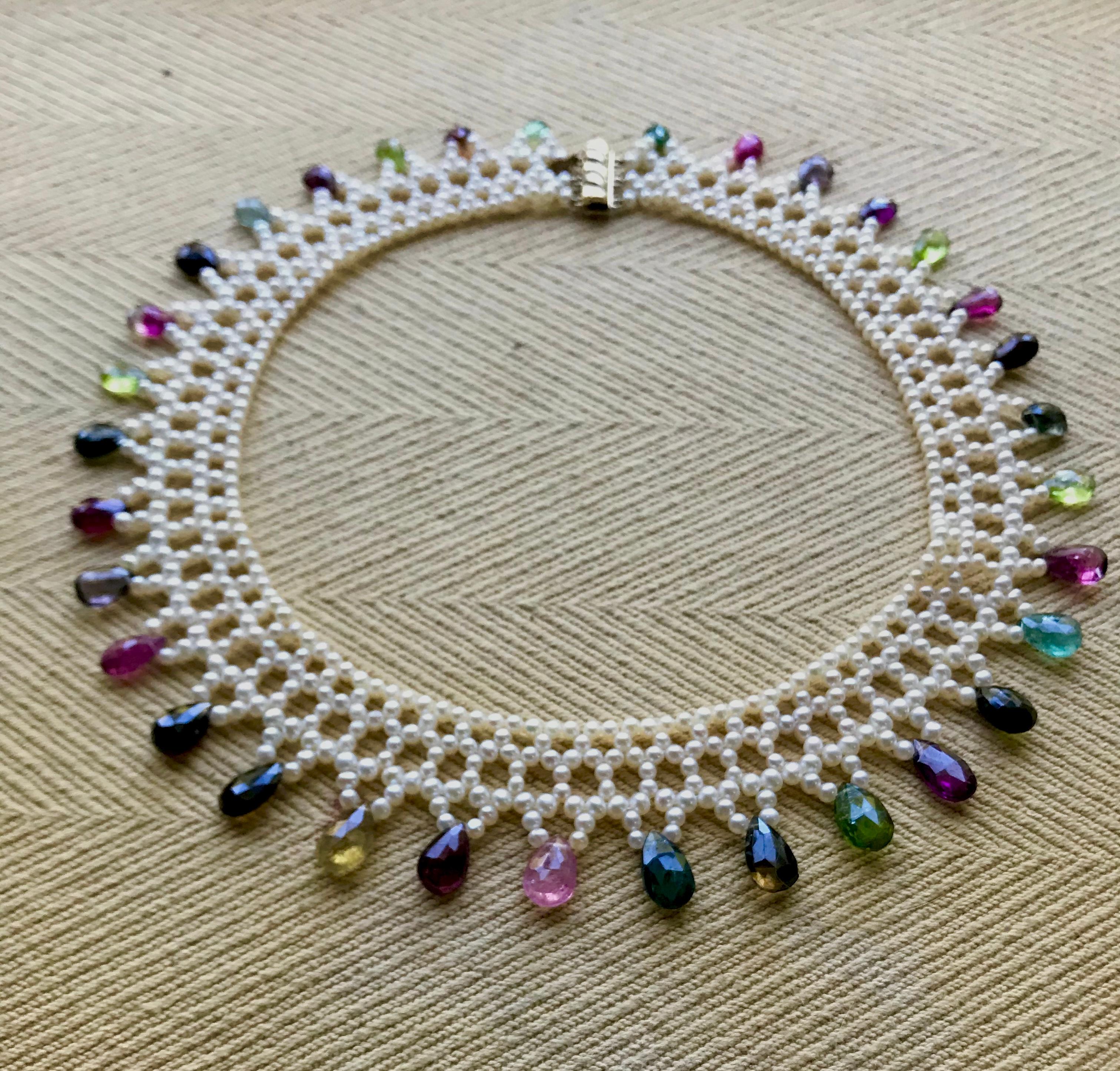 Diese handgeflochtene Halskette besteht aus 2 mm großen Zuchtperlen, die ein spitzenartiges Design ergeben, das perfekt zum Halsband passt. Die Halskette ist spitz zulaufend und passt sich der Rundung des Dekolletés an. Abgestufte mehrfarbige