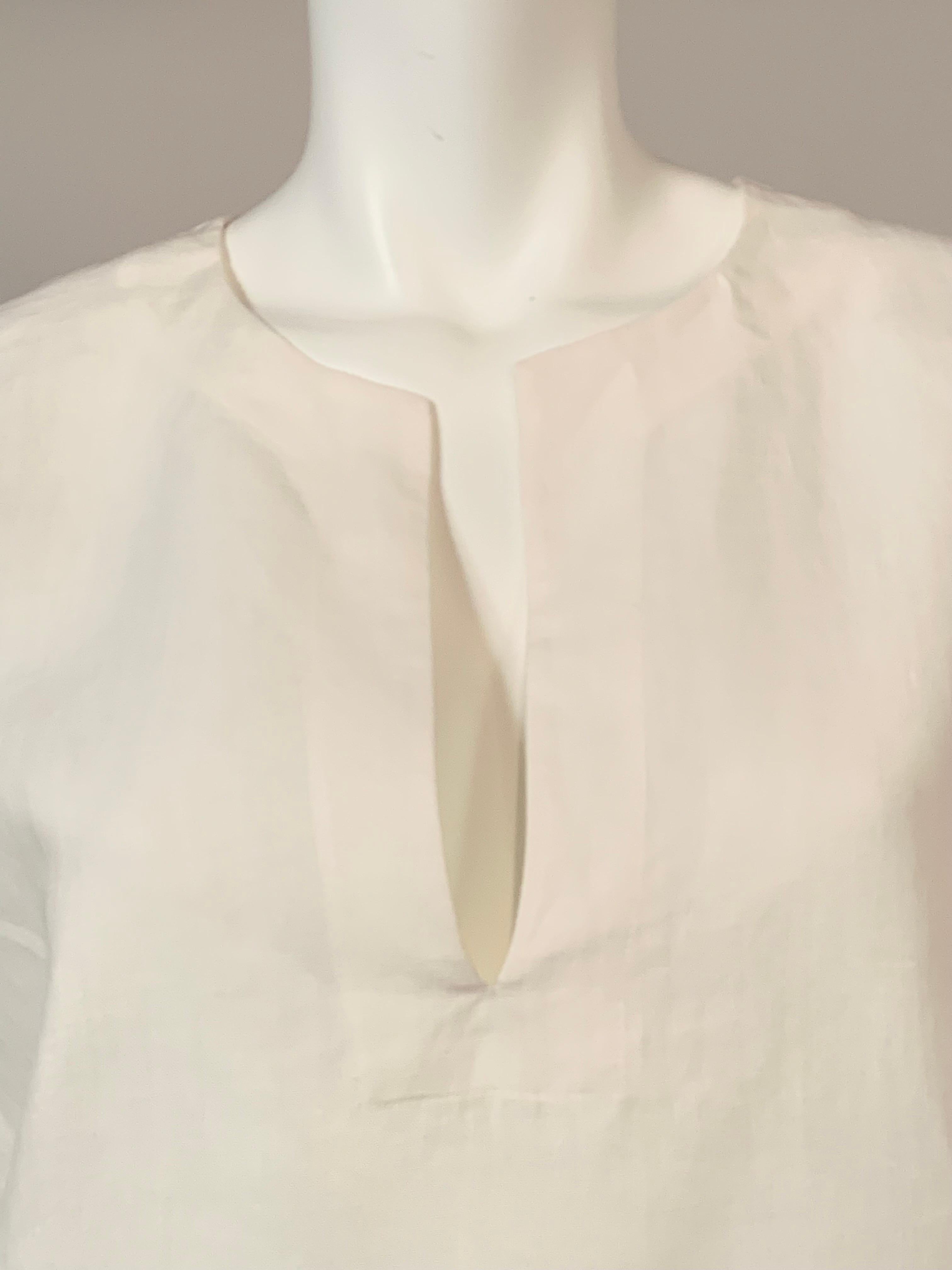 What could be cooler than a crisp white linen tunic in the summer?  Italian designer Marina Rinaldi created this tunic with a round neckline and a V shaped opening at the center front.  The sleeves are elbow length and there are openings on either