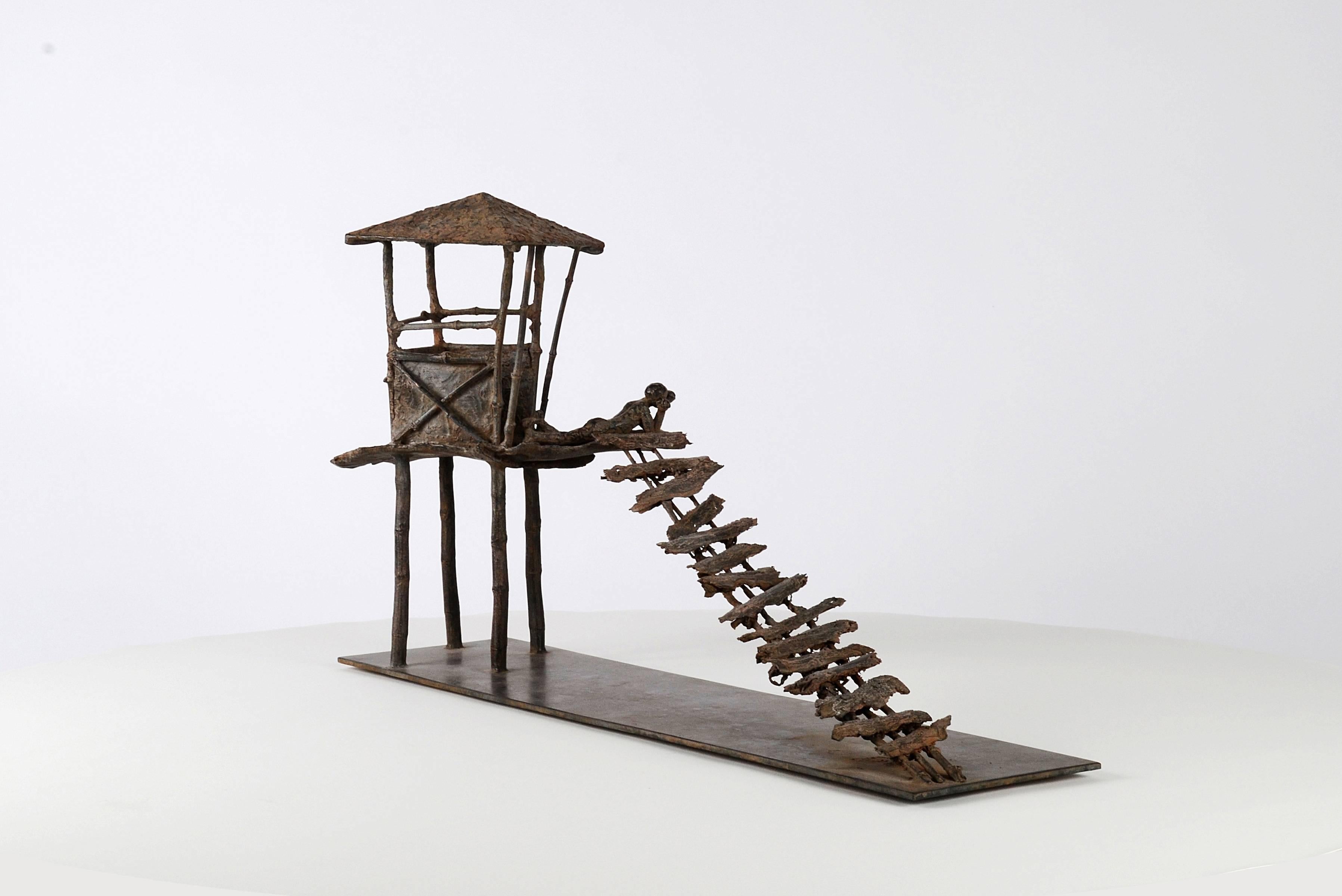 Die gebogenen Bretter (Les planches courbes) sind eine Bronzeskulptur der französischen zeitgenössischen Künstlerin Marine de Soos. Es stellt eine Hütte auf Stelzen dar, zu der eine prekäre Treppe führt. Ein junger Mann liegt auf der Plattform der