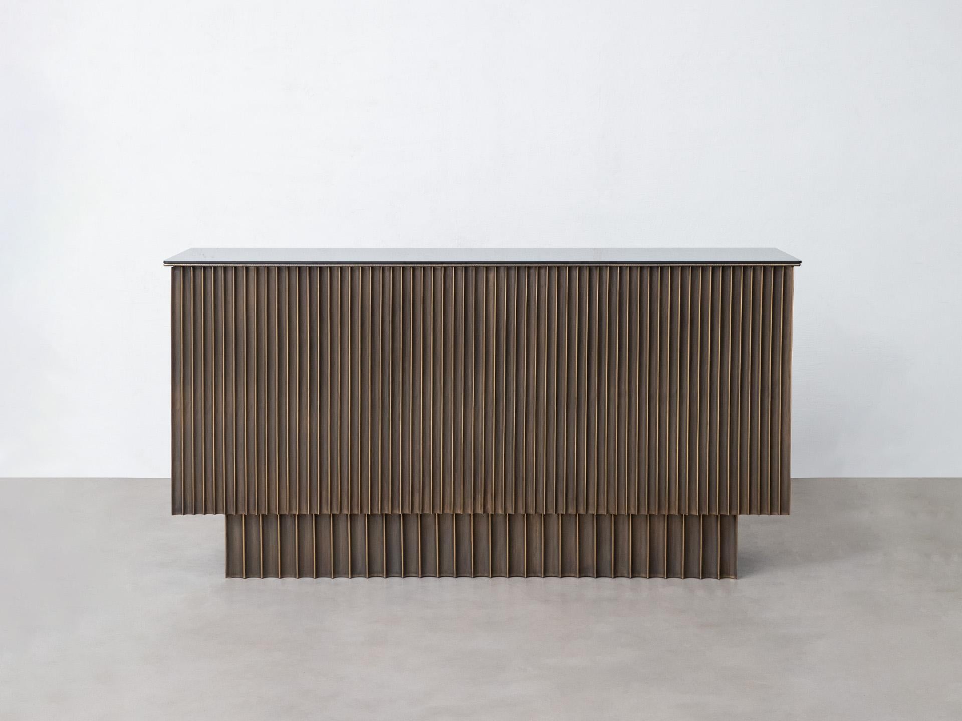 With an organic facade made of fluted brass, this sculptural console is inspired by Art Deco. Breaking away from the traditional confines of geometry, the console explores the dynamism of sheet brass and the highly-skilled technique of fluting, in