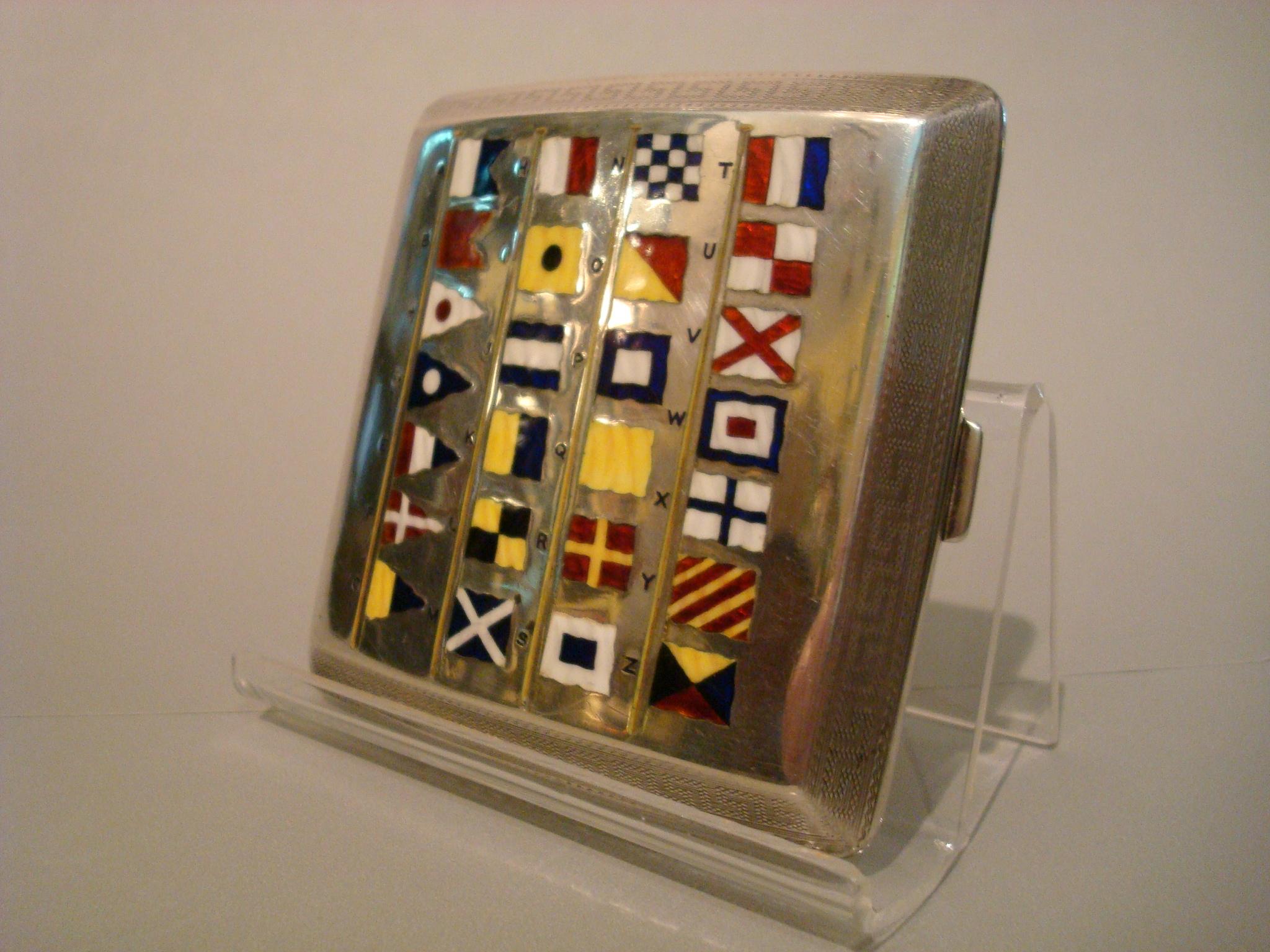 A sterling silver large engine turned cigarette or card case featuring hand painted, vitreous enamel, alphabet of the marine Signal flags. This is a stunning example of a large size case, in superb original, untouched condition. Marks say it was