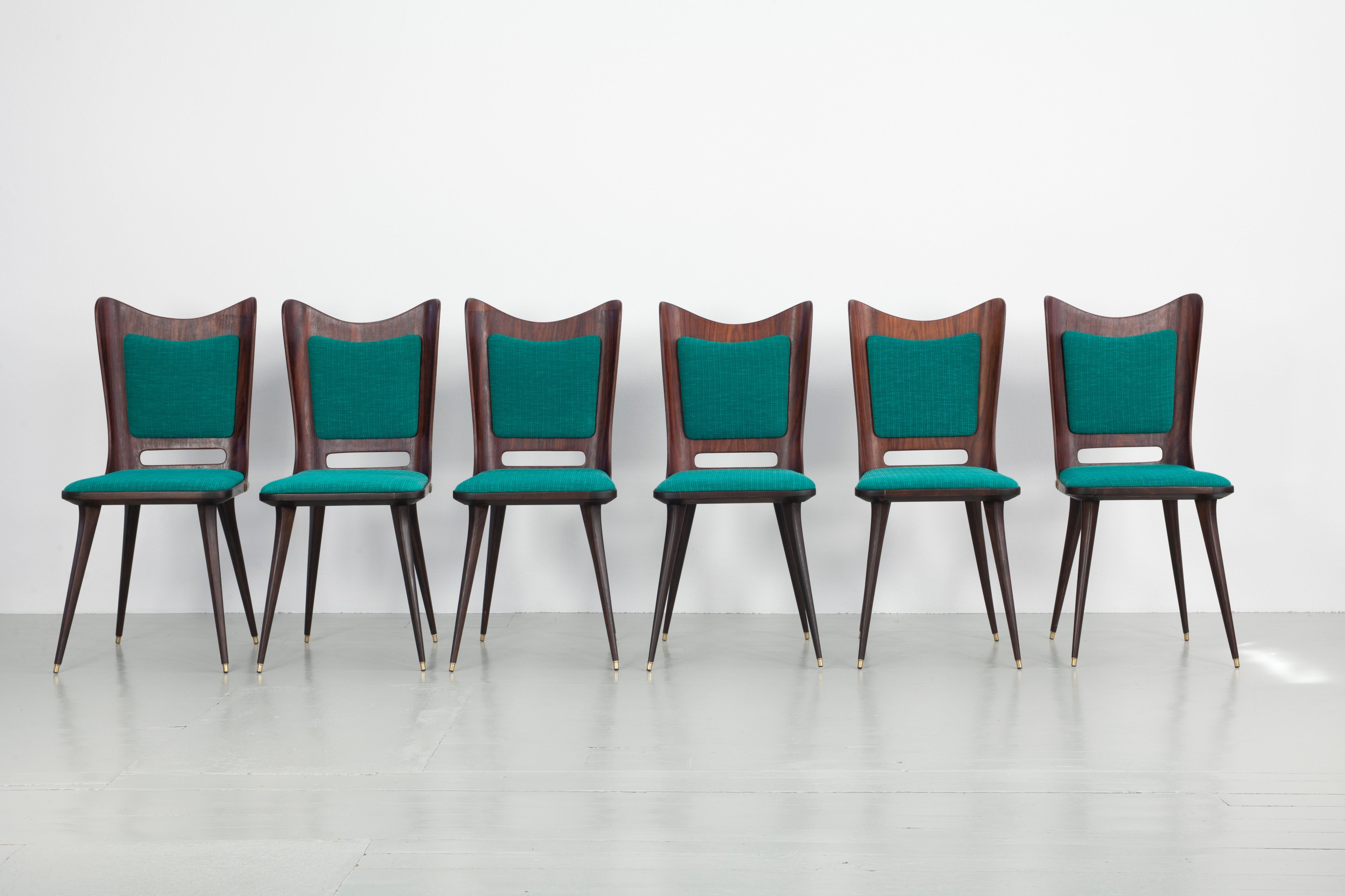 This set of six dining chairs was designed by Carlo Ratti in Italy in the 1950s. The dark rosewood contrasts with the turquoise vintage upholstery and the colour combination makes the chairs look classy and elegant. All pieces have been completely