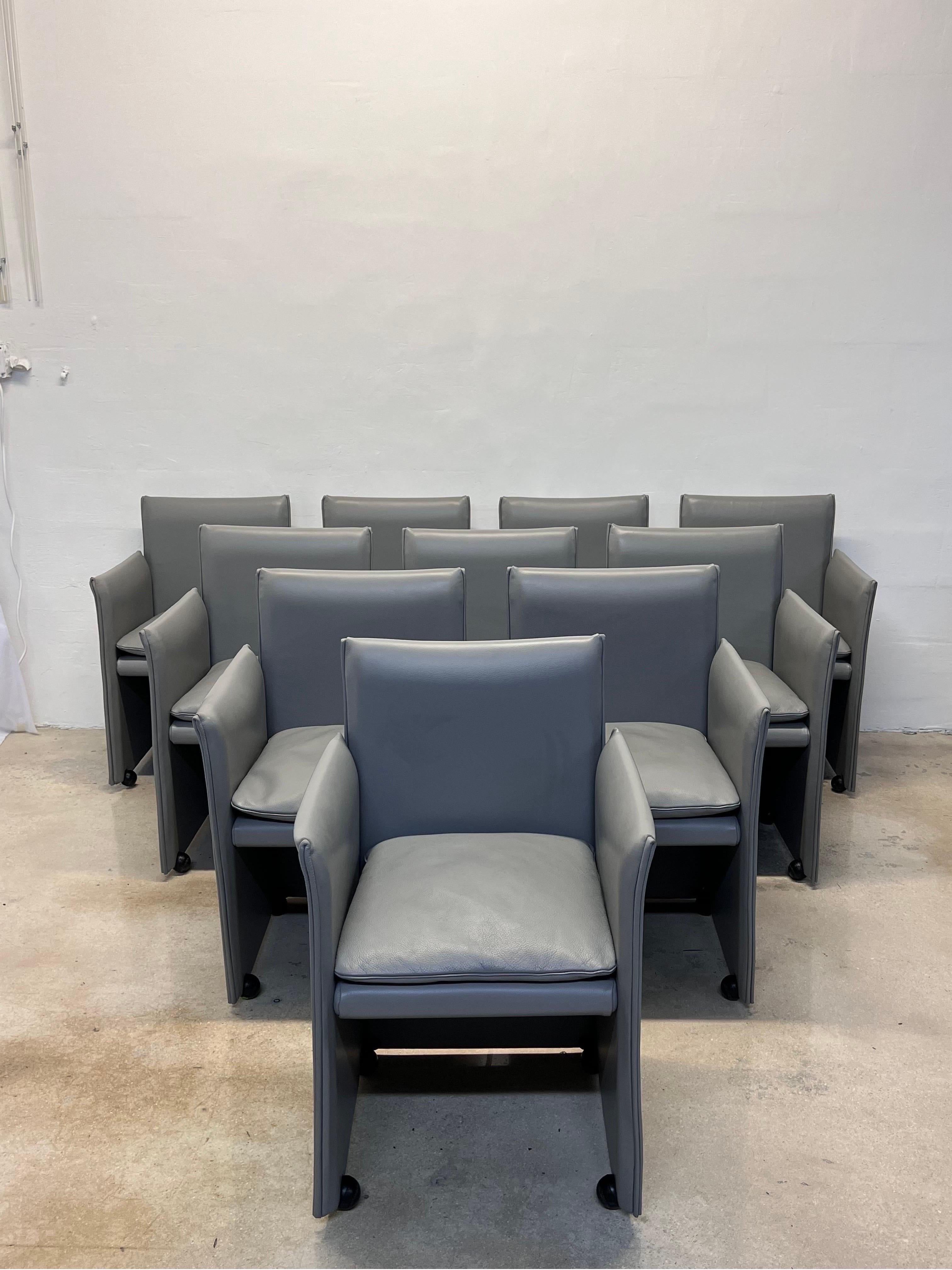 Rare set of ten gray leather 401 Break dining arm chairs on casters designed by Mario Bellini for Cassina Spa. The chairs have soft down filled cushions and the leather is wrapped over a steel frame.

Arm Height: 26