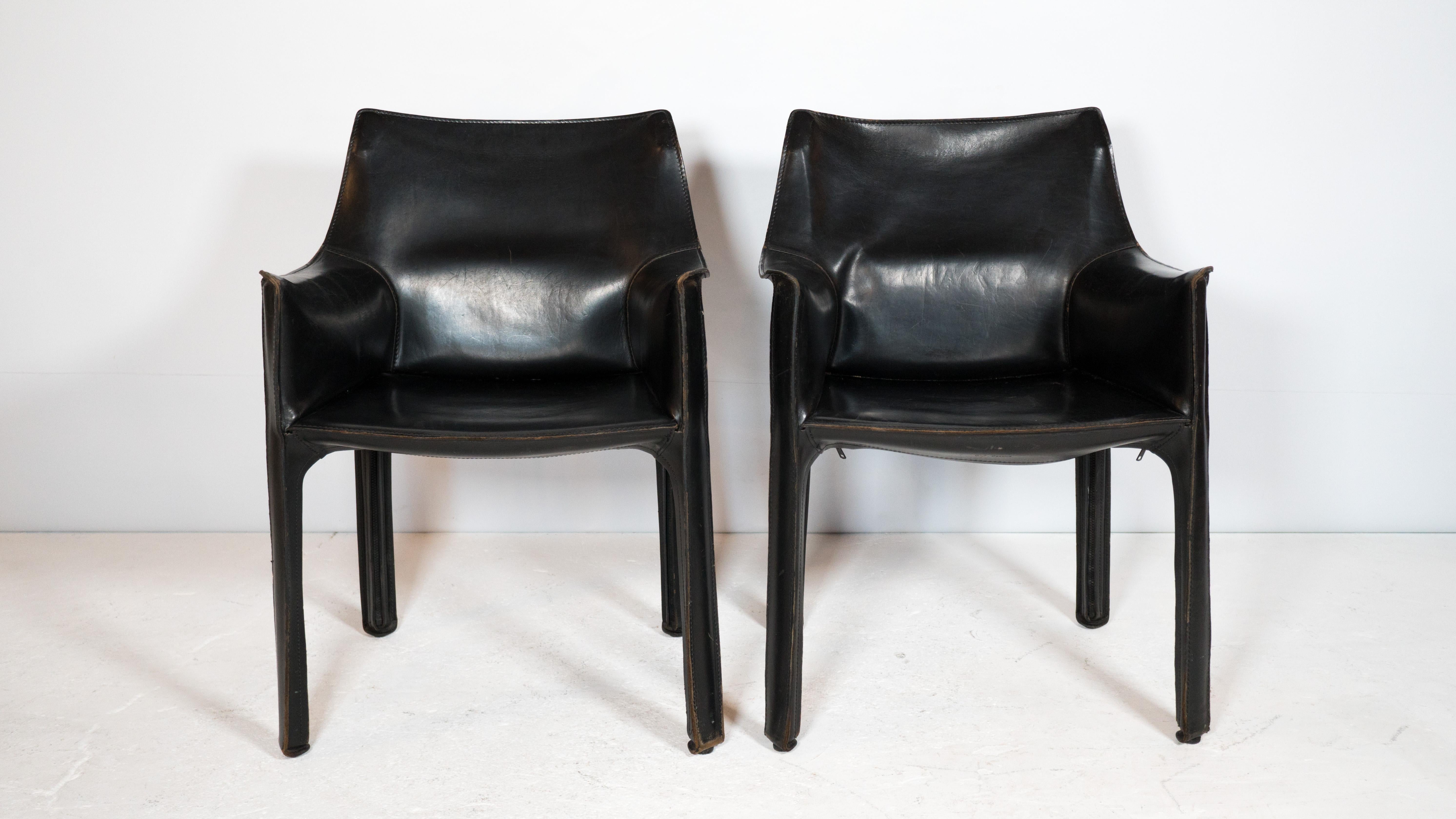 Mario Bellini '413 Cab' armchairs for Cassina, circa 1980s. Presented in black leather with exposed stitching details. The cowhide leather wraps around all sides of the steel frame, influenced by the human body and how skin wraps around one's