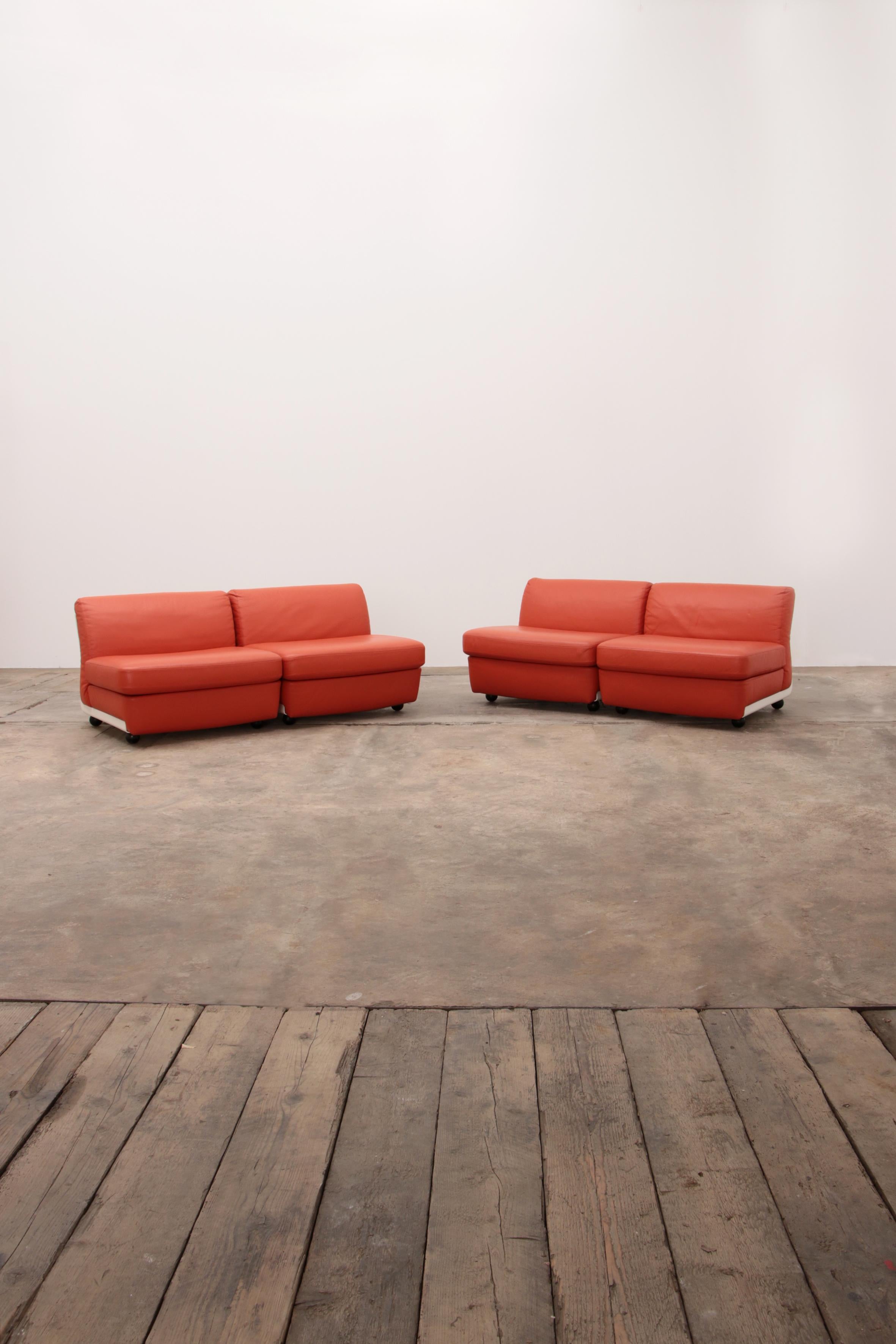Mario Bellini Amanta modular sofa in orange leather for C&B Italy, 1960s.

Four separate elements can be used as lounge chairs or sofa.

The shells are white fiberglass and the seats are upholstered with the original orange leather upholstery.