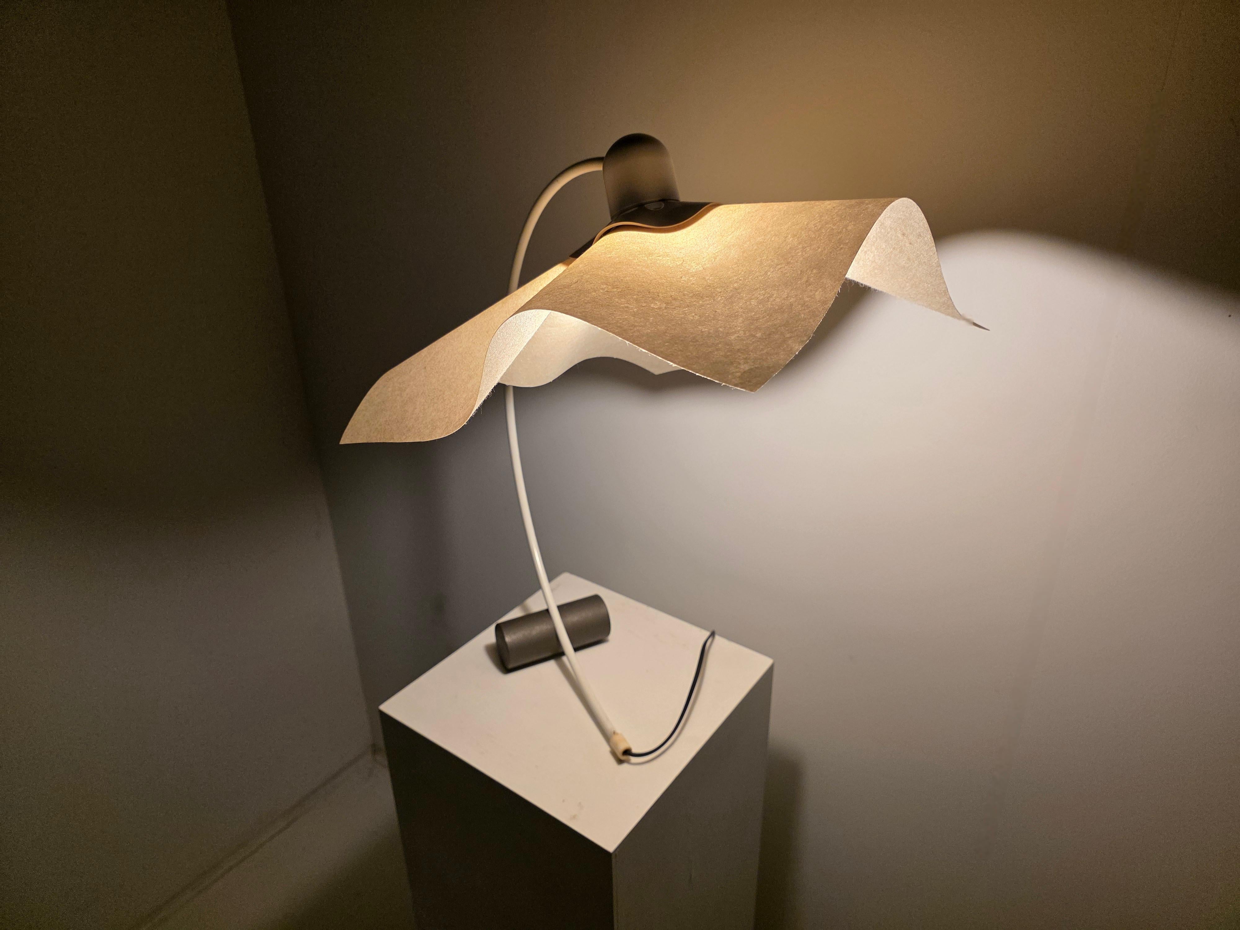 La lámpara de sobremesa Area Curvea, diseñada por Mario Bellini para Artemide en los años 70, es un icono escultural del diseño italiano.

Su pantalla de resina suavemente drapeada y su brazo metálico curvado crean una silueta poética pero funcional
