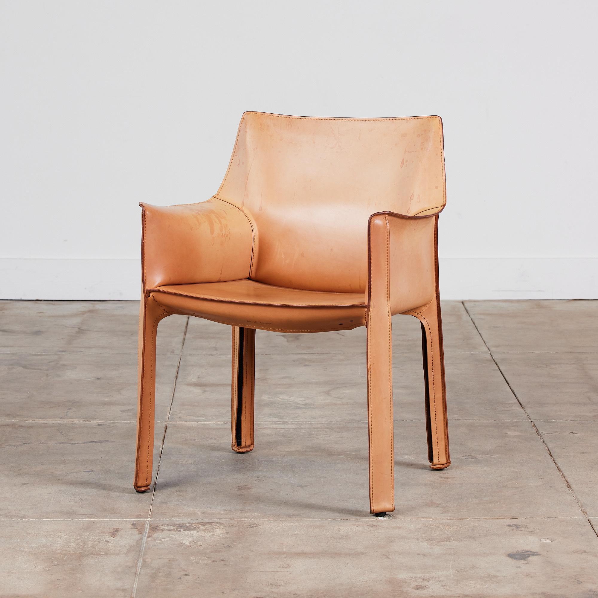 This iconic chair designed by Mario Bellini for Cassina c.1970s, Italy, features the original cognac saddle leather which is wrapped atop a steel frame. The back legs feature a black zippered detail. The chair can easily be used for dining or an